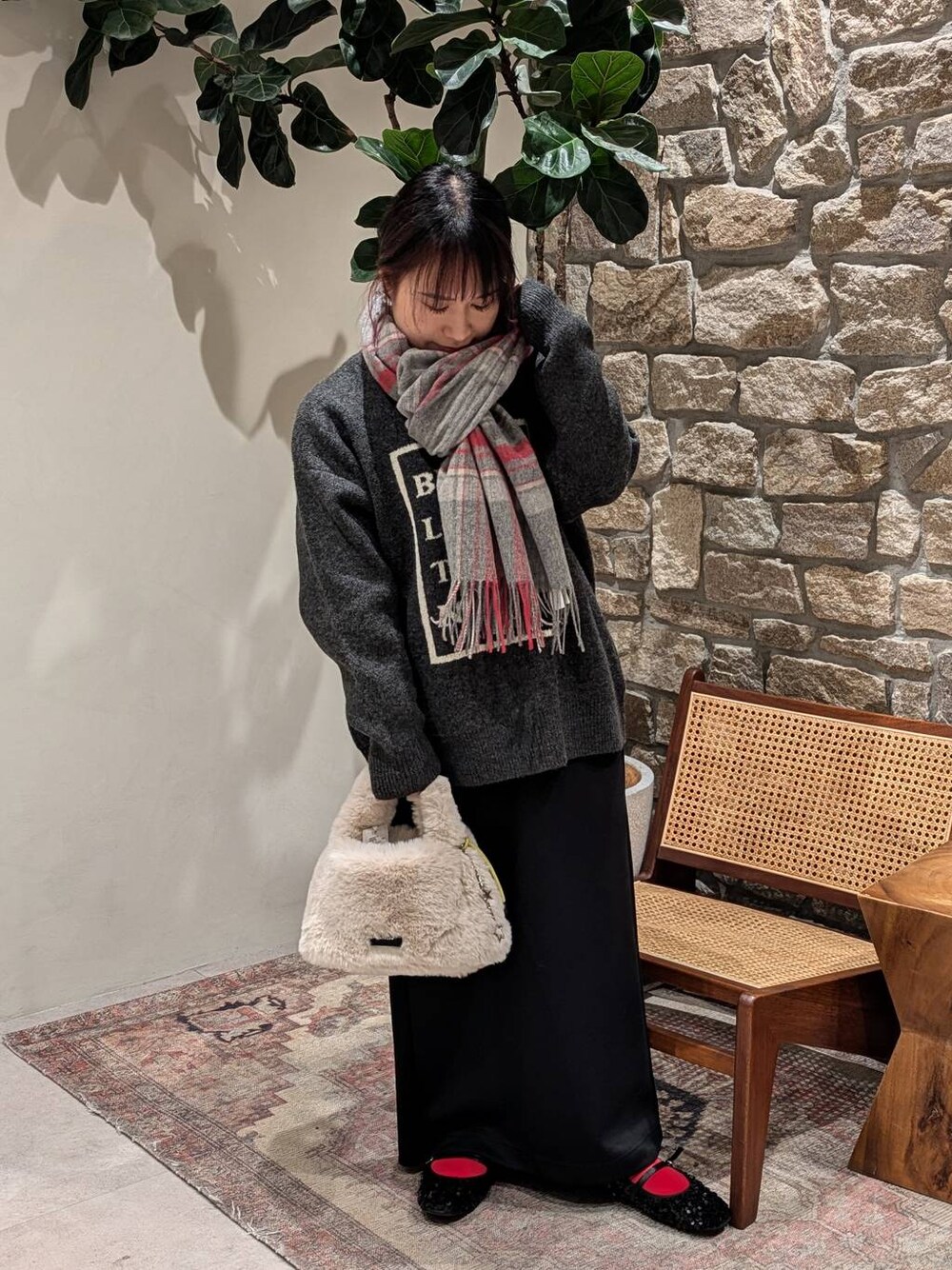 ブラック系のバレエシューズ、ホワイト系のショルダーバッグ、グレー系のニット/セーターを着用したレディースの冬コーディネートの1枚目の写真