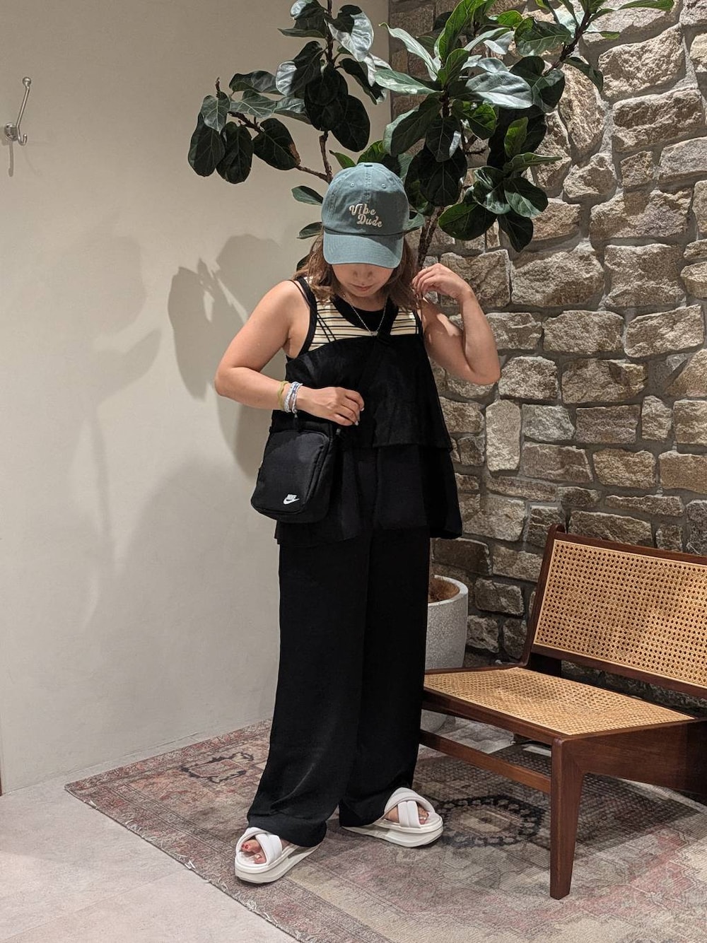 ブラック系のその他トップス、ブラック系のその他パンツ、グリーン系のキャップを着用したレディースの夏コーディネートの1枚目の写真