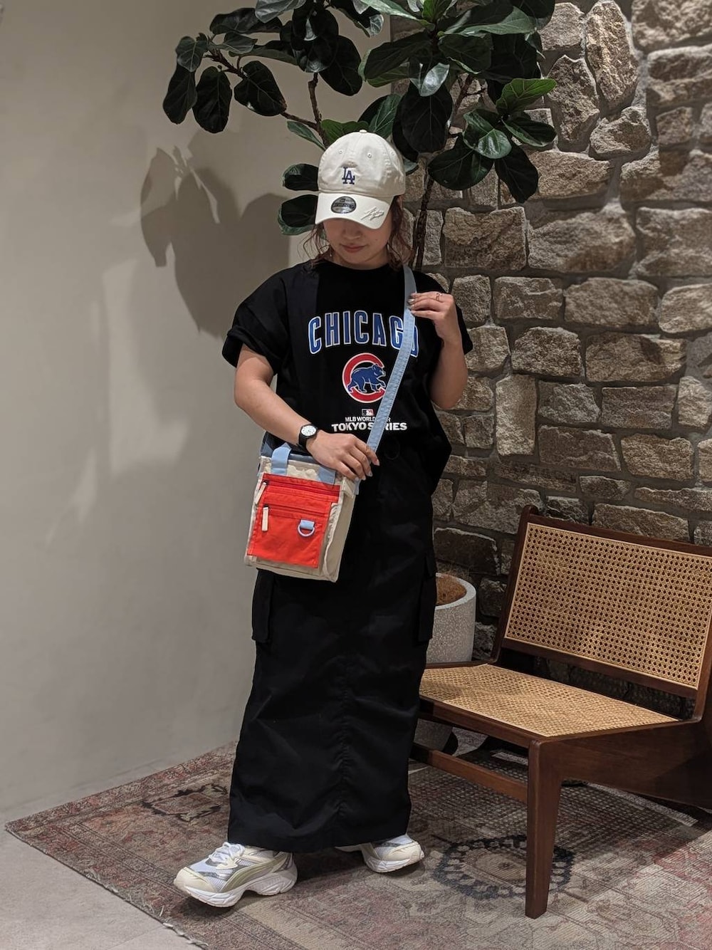 ホワイト系のスニーカー、ベージュ系のショルダーバッグ、ブラック系のスカートを着用したレディースの春コーディネートの1枚目の写真