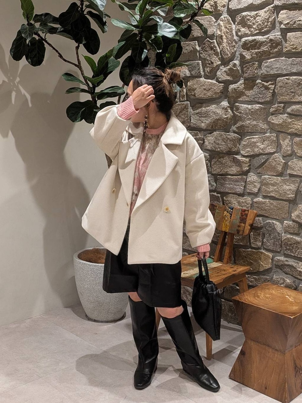 ブラック系のブーツ、ブラック系のハンドバッグを着用したレディースの秋コーディネートの1枚目の写真