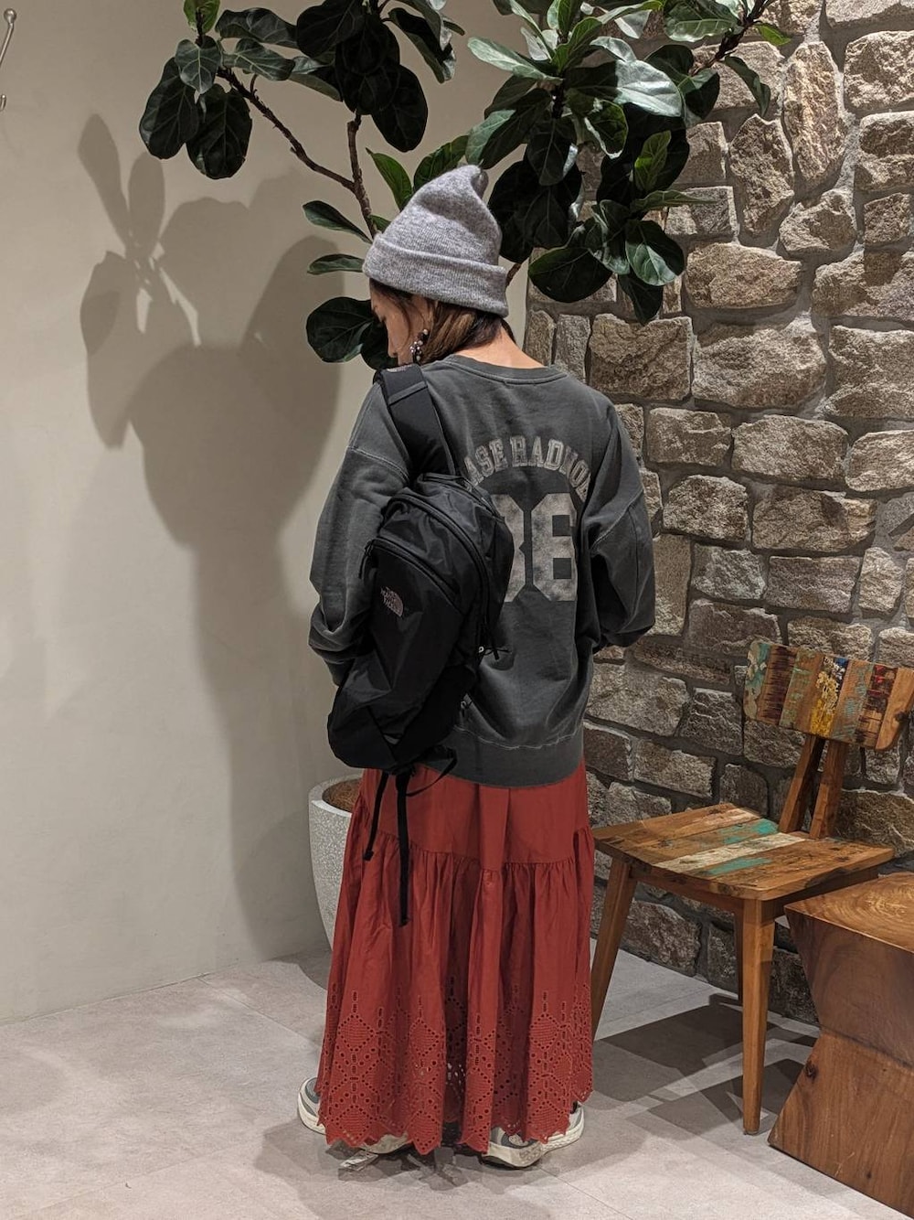 グレー系のスニーカー、ブラック系のバックパック/リュック、グレー系のスウェットを着用したレディースの秋コーディネートの1枚目の写真