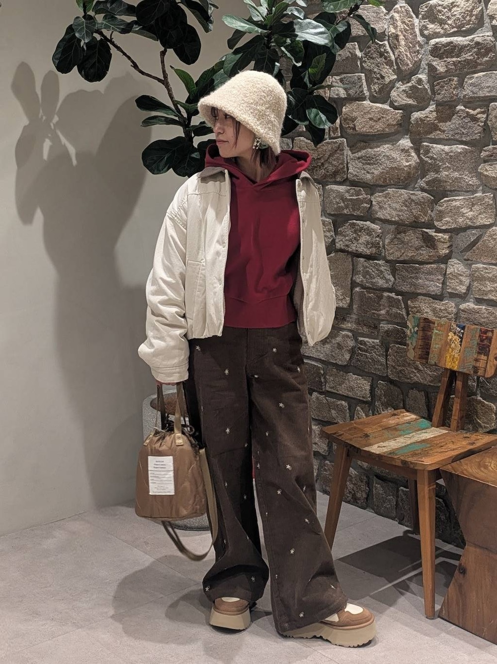 ブラウン系のその他パンツ、レッド系のパーカー、ベージュ系のショルダーバッグを着用したレディースの冬コーディネートの1枚目の写真