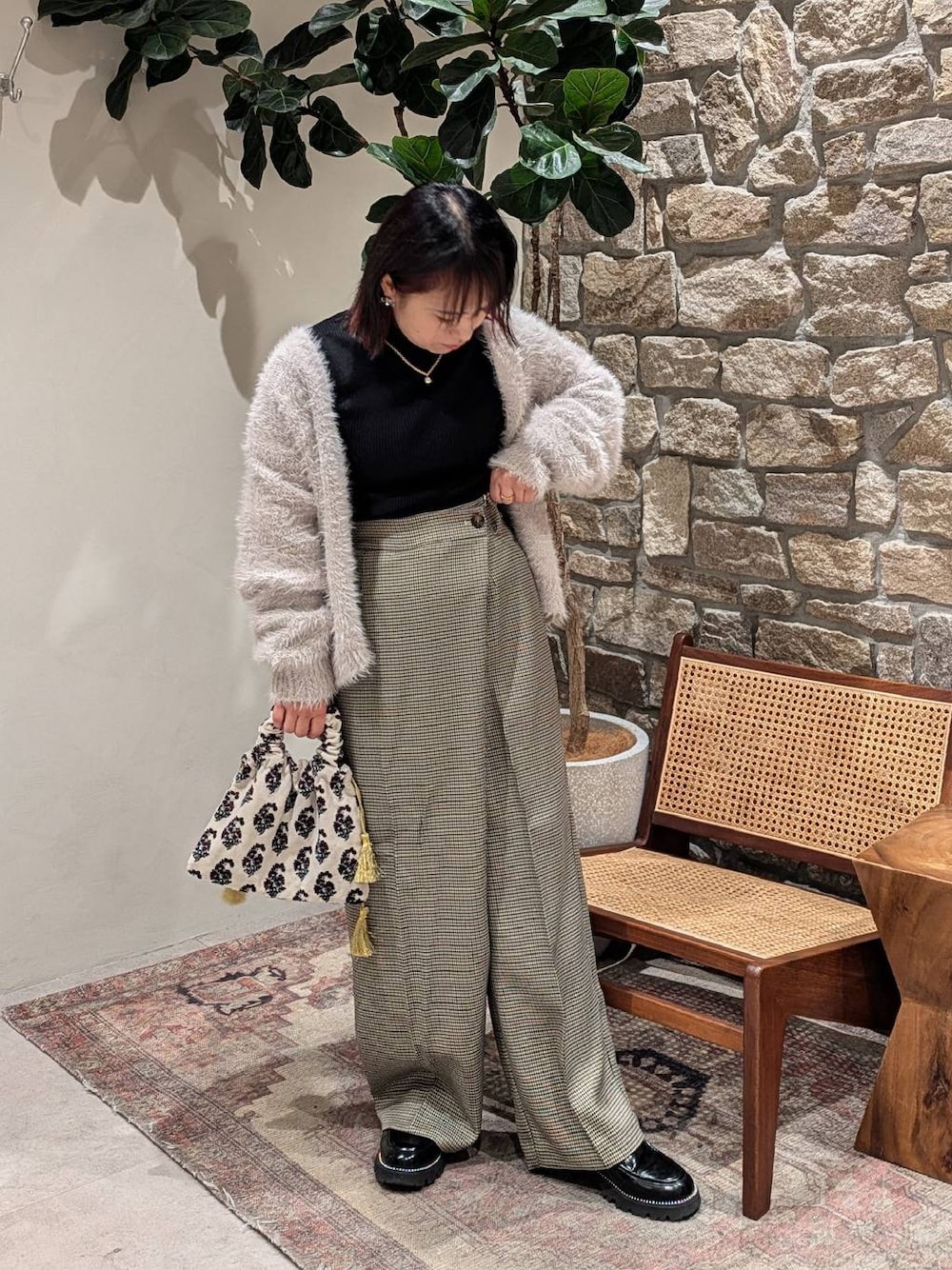 ブラック系のニット/セーター、ブラック系のローファー、グレー系のカーディガン/ボレロを着用したレディースの冬コーディネートの1枚目の写真