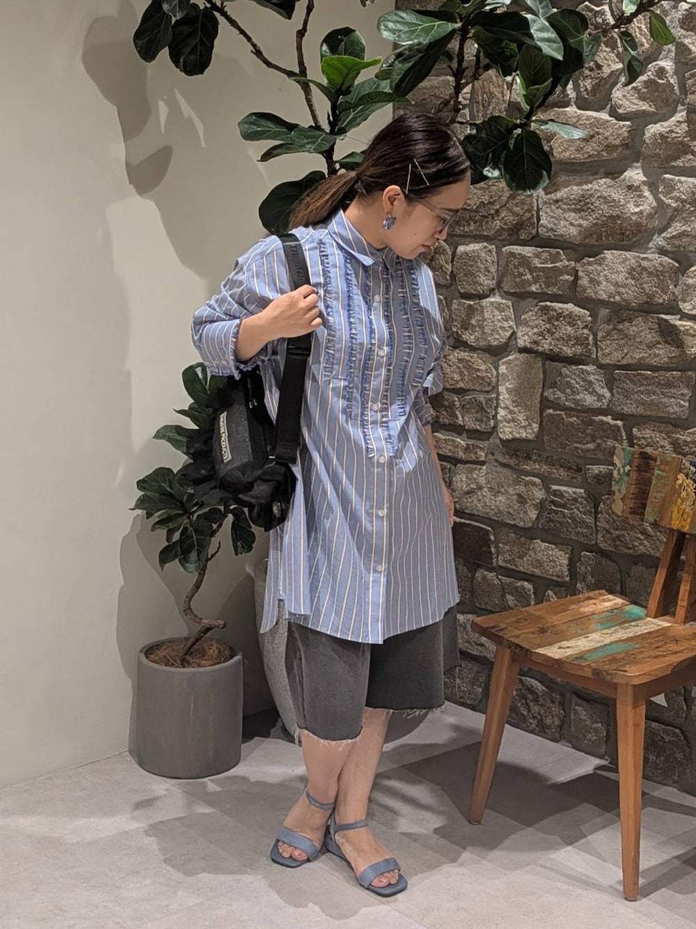 ブルー系のチュニック、ブルー系のサンダル、ブラック系のショルダーバッグを着用したレディースの夏コーディネートの1枚目の写真