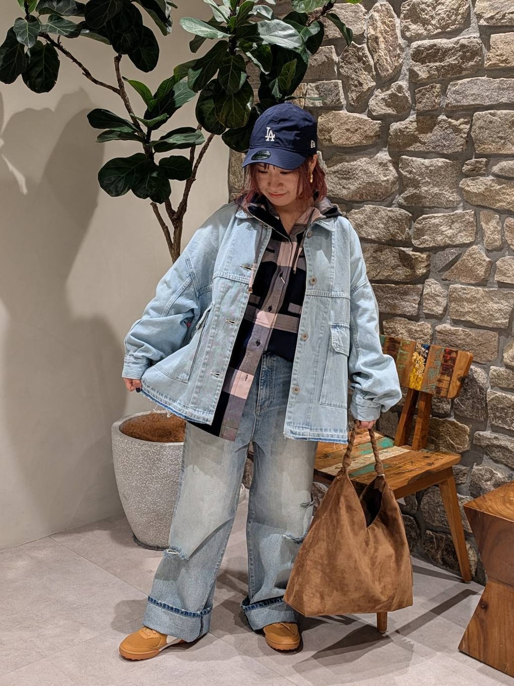 ブラウン系のトートバッグ、ブルー系のデニムパンツ、ブルー系のシャツ/ブラウスを着用したレディースの冬コーディネートの1枚目の写真