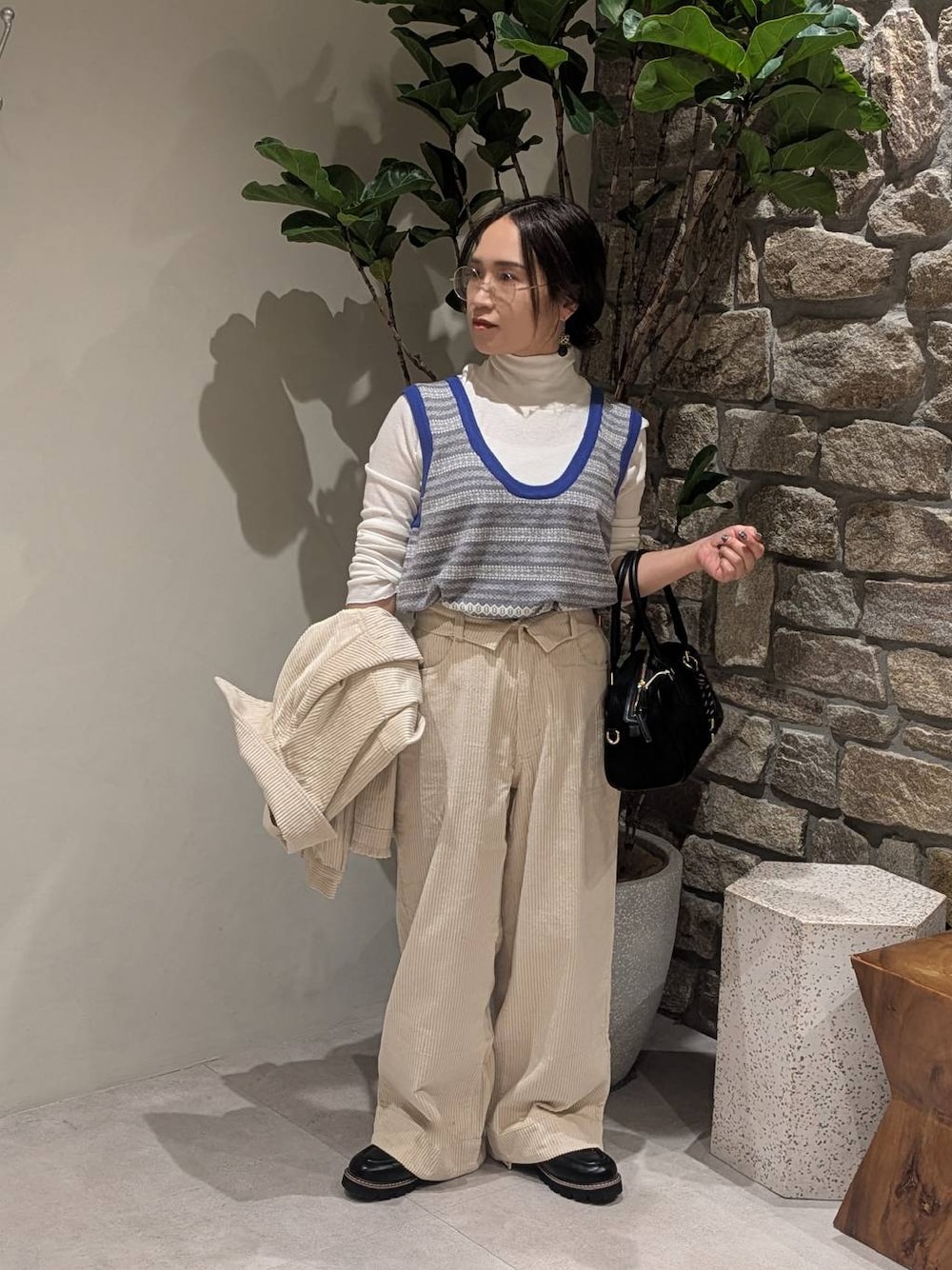 ホワイト系のブルゾン、ホワイト系のその他パンツ、ブラック系のハンドバッグを着用したレディースの秋コーディネートの1枚目の写真