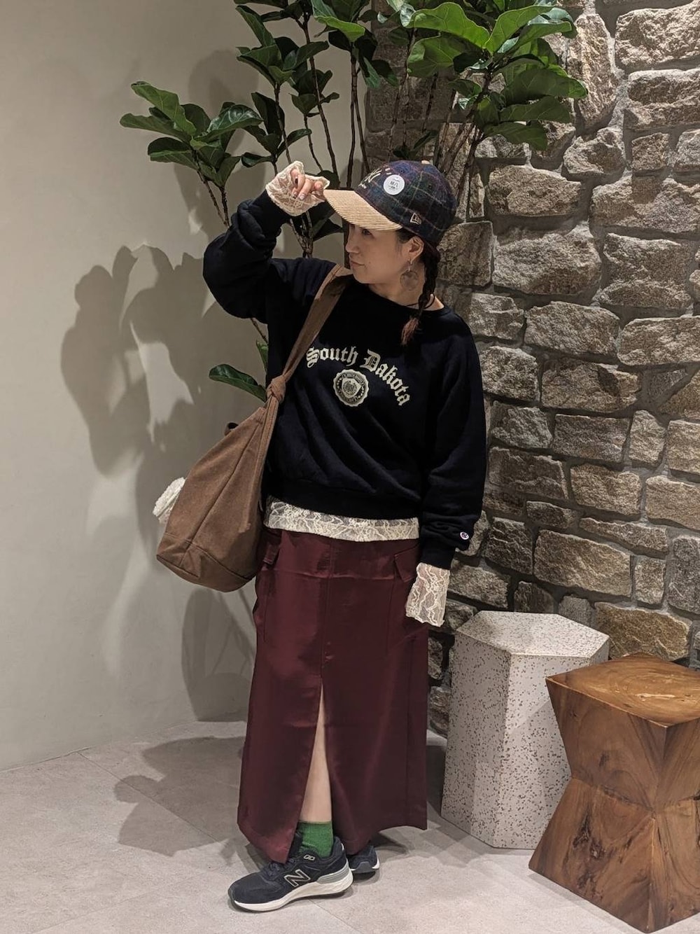 レッド系のスカート、ホワイト系のTシャツ/カットソー、ブルー系のスニーカーを着用したレディースの秋コーディネートの1枚目の写真