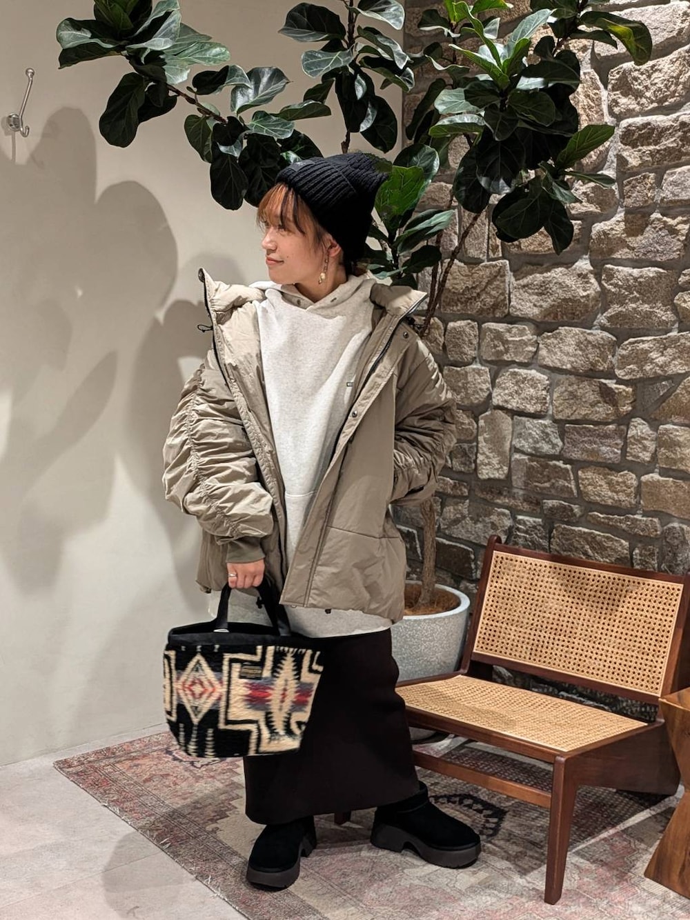 ブラウン系のスカート、グリーン系のブルゾン、グレー系のパーカーを着用したレディースの秋コーディネートの1枚目の写真