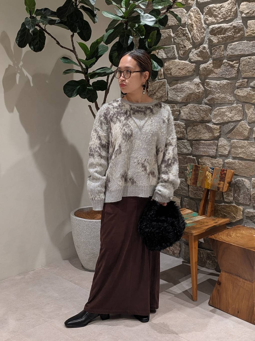 ブラウン系のスカート、ブラック系のブーツ、グレー系のニット/セーターを着用したレディースの秋コーディネートの1枚目の写真