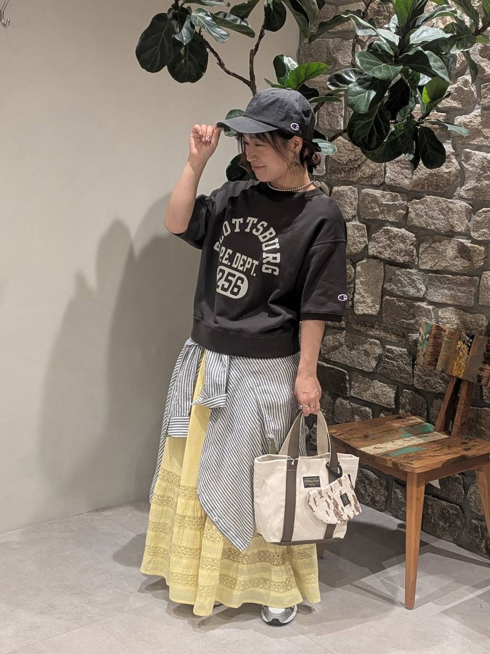 グレー系のスニーカー、ブラック系のTシャツ/カットソー、ベージュ系のトートバッグを着用したレディースの春コーディネートの1枚目の写真