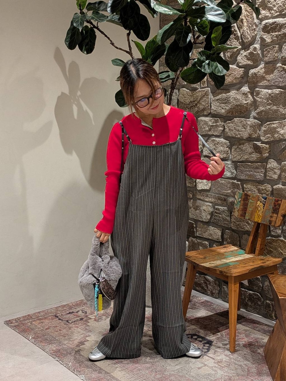 グレー系のスニーカー、レッド系のカーディガン/ボレロ、グレー系のハンドバッグを着用したレディースの秋コーディネートの1枚目の写真