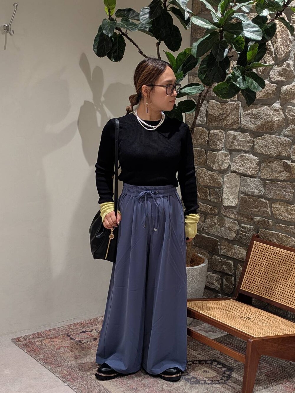 ブルー系のその他パンツ、ブラック系のニット/セーター、ブラック系のローファーを着用したレディースの夏コーディネートの1枚目の写真