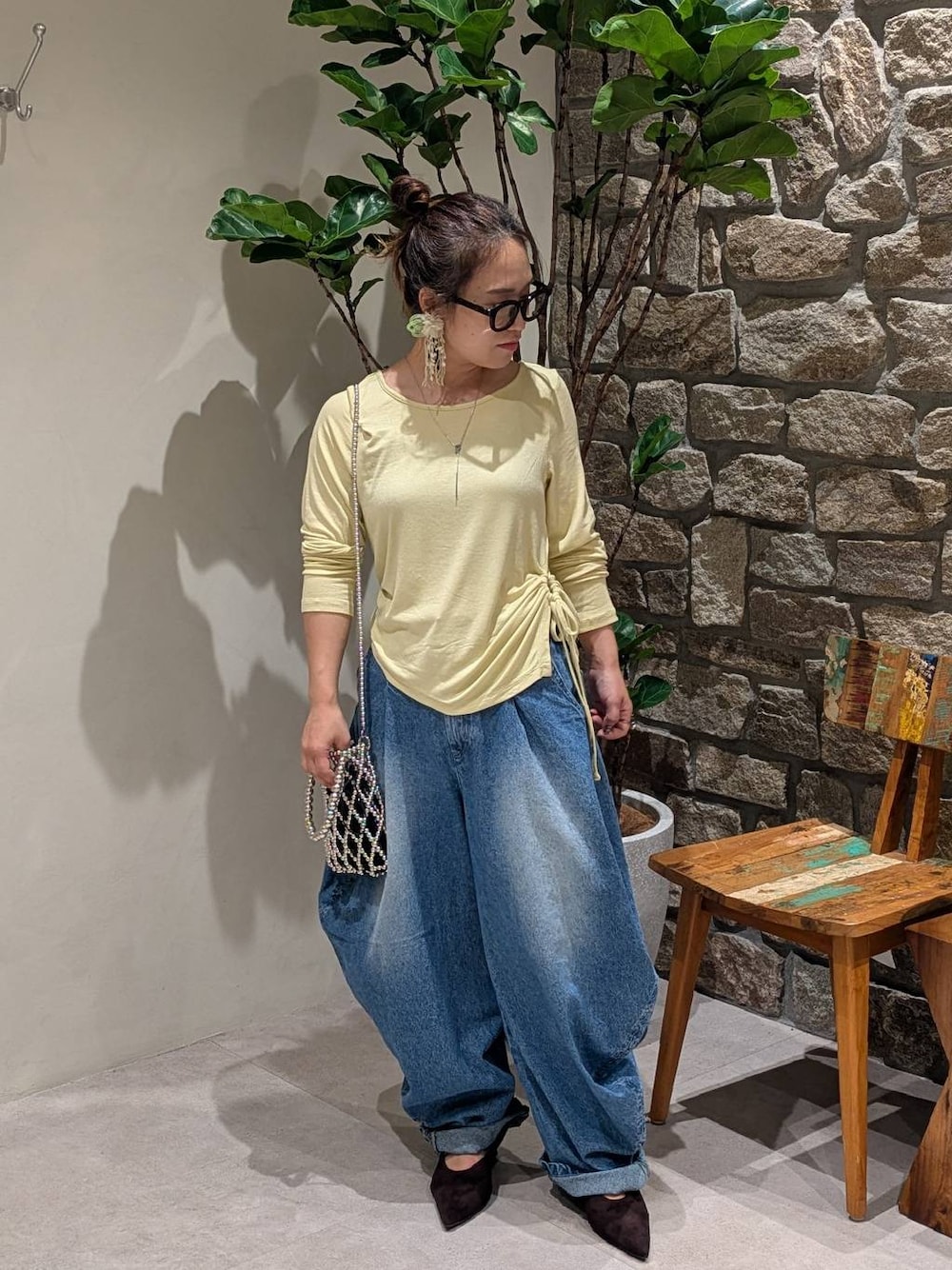 シルバー系のショルダーバッグ、ブラウン系のパンプス、イエロー系のTシャツ/カットソーを着用したレディースの秋コーディネートの1枚目の写真