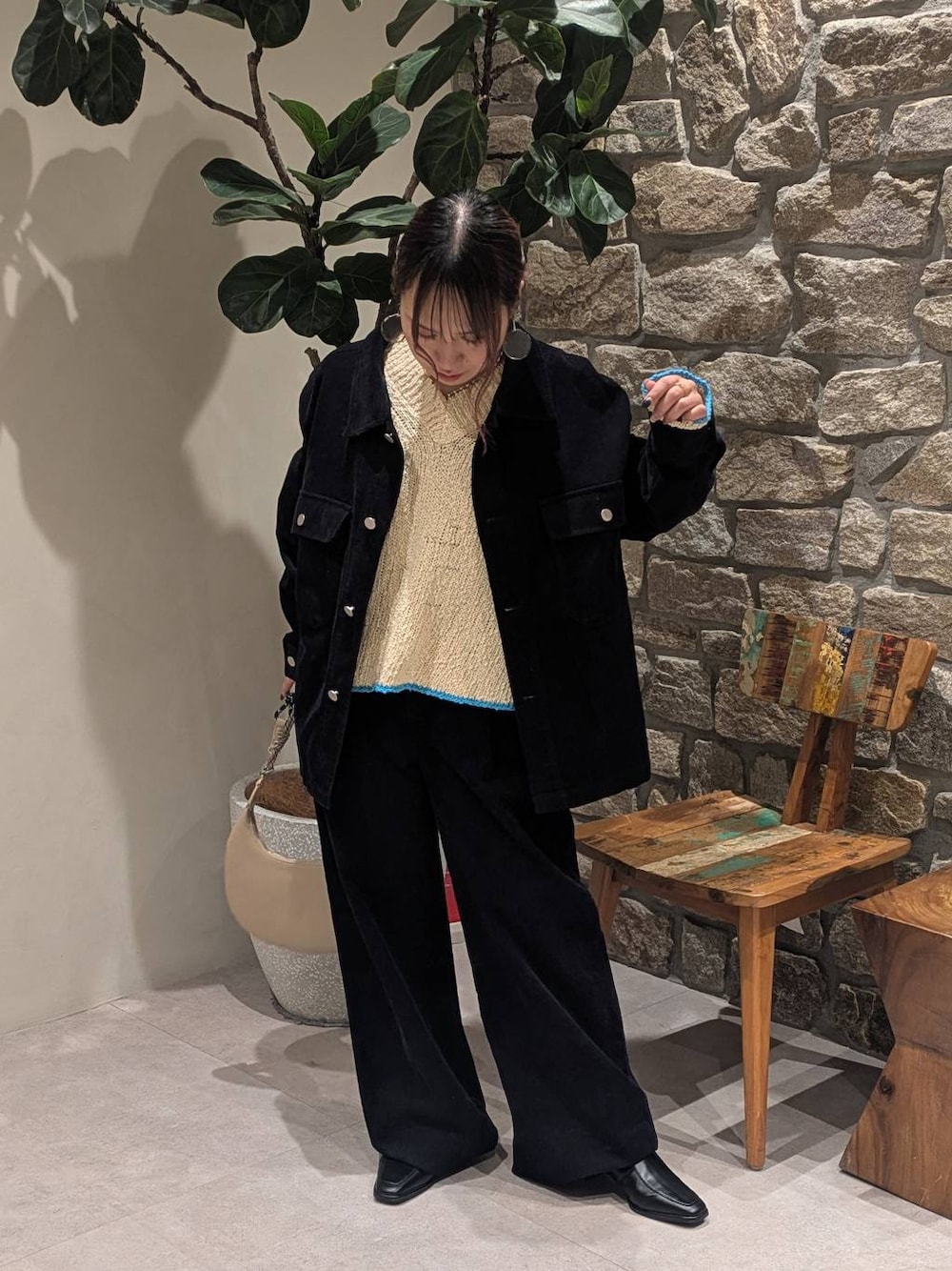 ベージュ系のハンドバッグ、ブラック系のブーツ、ホワイト系のニット/セーターを着用したレディースの冬コーディネートの1枚目の写真