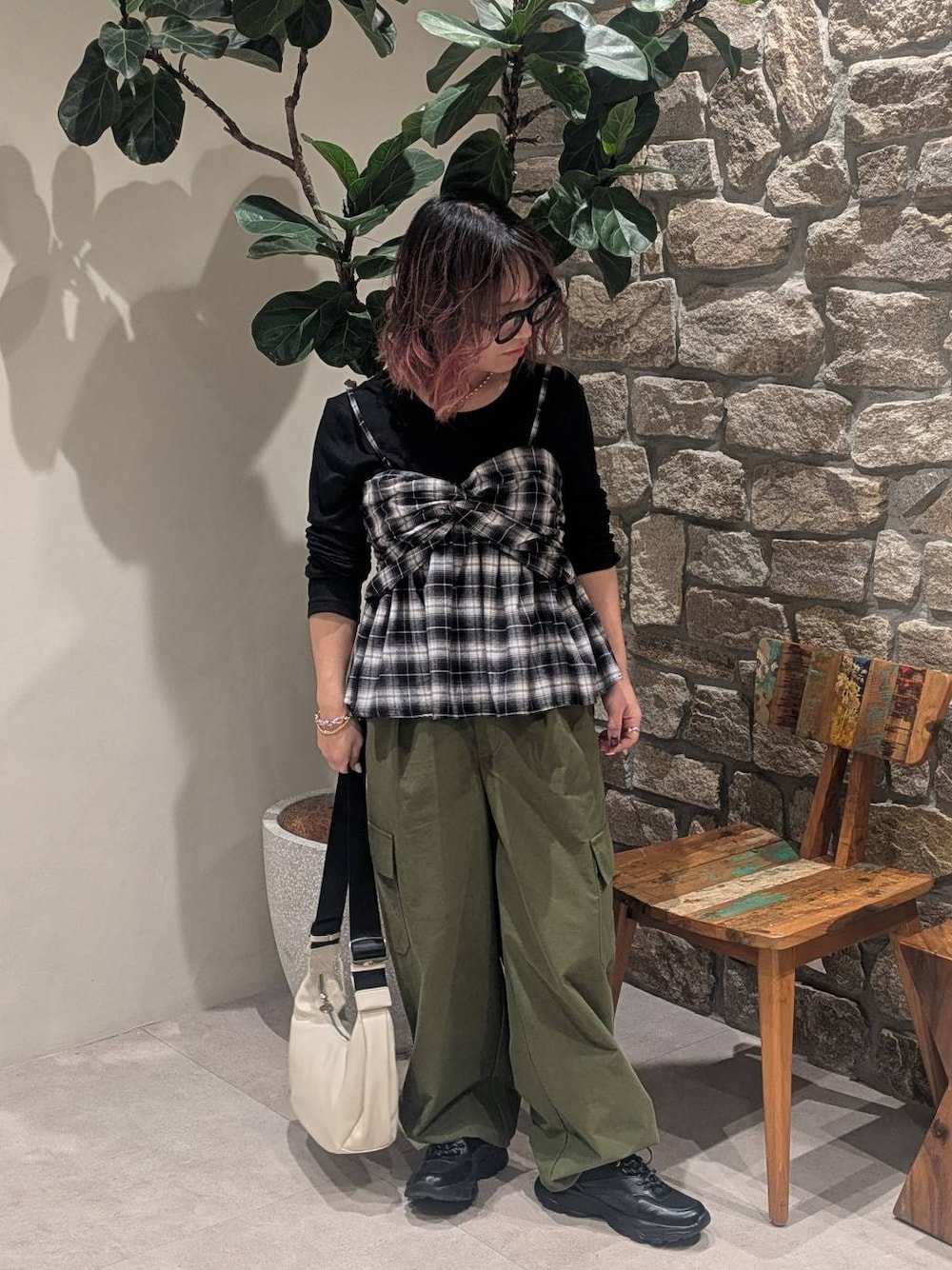 ブラック系のスニーカー、ブラック系のキャミソール、ホワイト系のショルダーバッグを着用したレディースの冬コーディネートの1枚目の写真