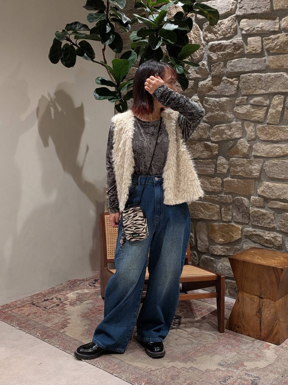 ベージュ系のショルダーバッグ、ブルー系のデニムパンツ、グレー系のTシャツ/カットソーを着用したレディースの冬コーディネートの1枚目の写真