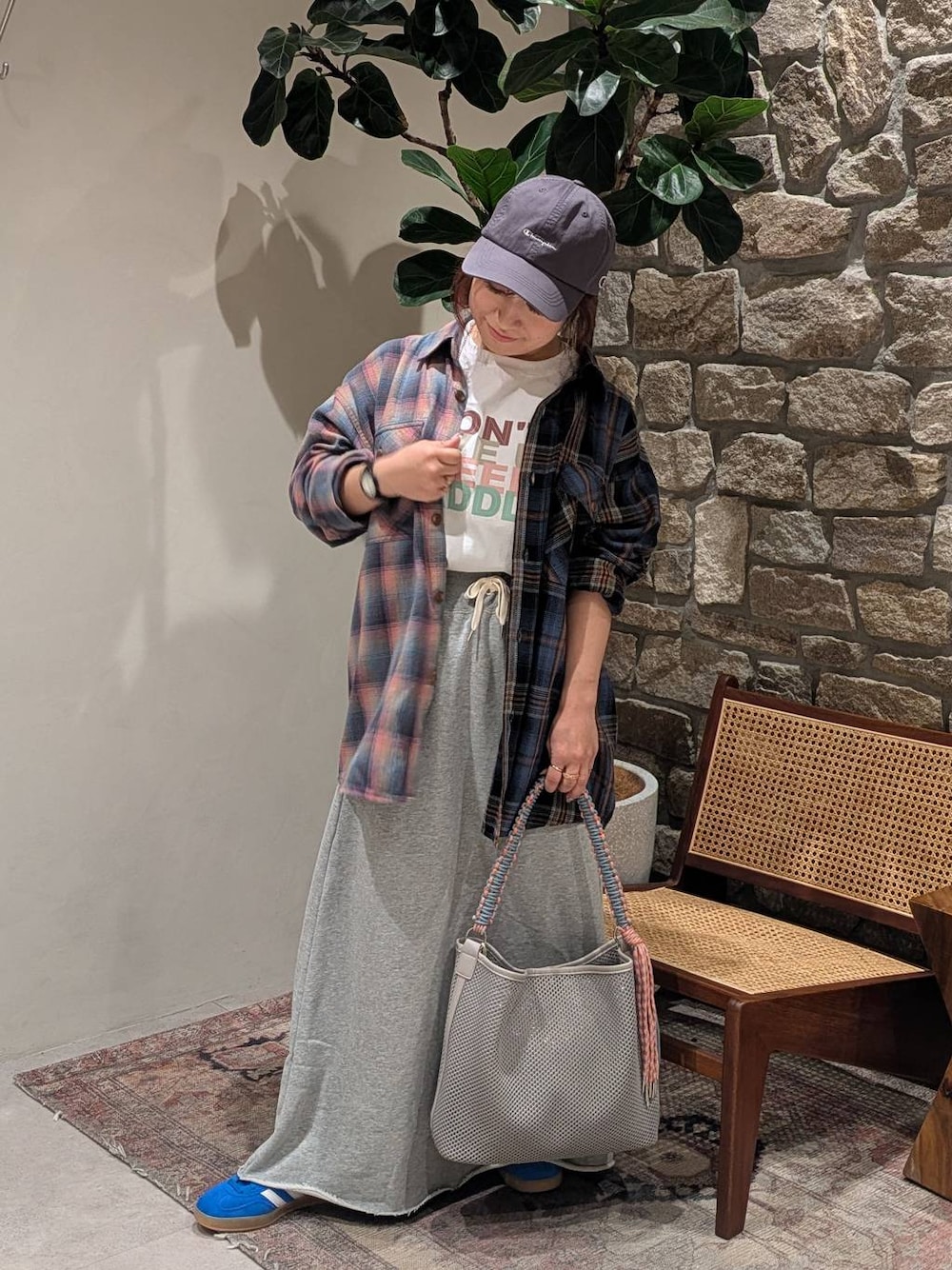 ブルー系のスニーカー、グレー系のスカート、ホワイト系のTシャツ/カットソーを着用したレディースの春コーディネートの1枚目の写真