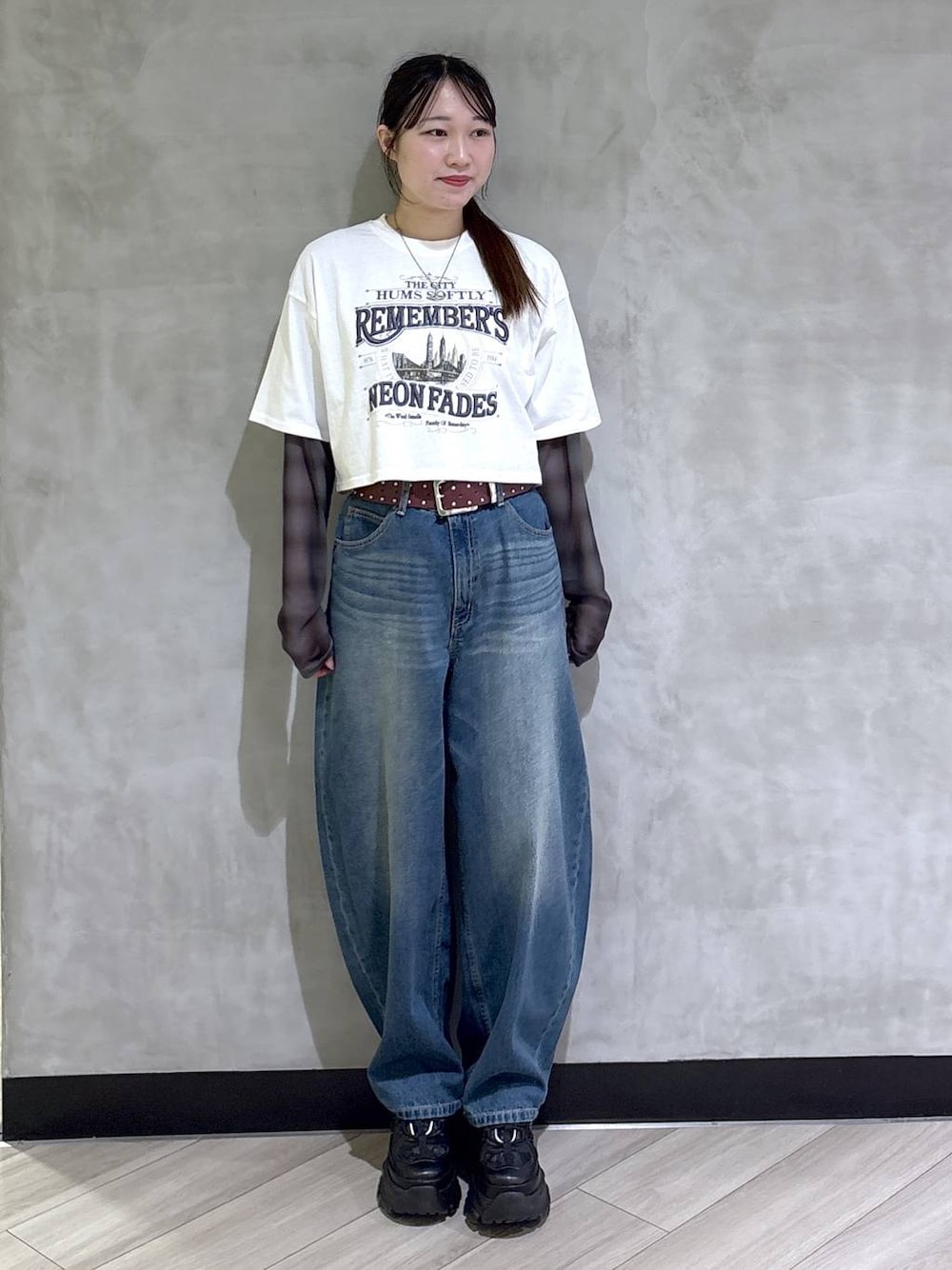 ブラック系のスニーカー、ホワイト系のTシャツ/カットソー、ブルー系のデニムパンツを着用したレディースの春コーディネートの1枚目の写真