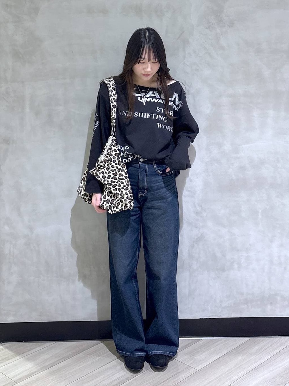 ブルー系のスラックス、ブラック系のモカシン/デッキシューズ、ブラック系のTシャツ/カットソーを着用したレディースの冬コーディネートの1枚目の写真