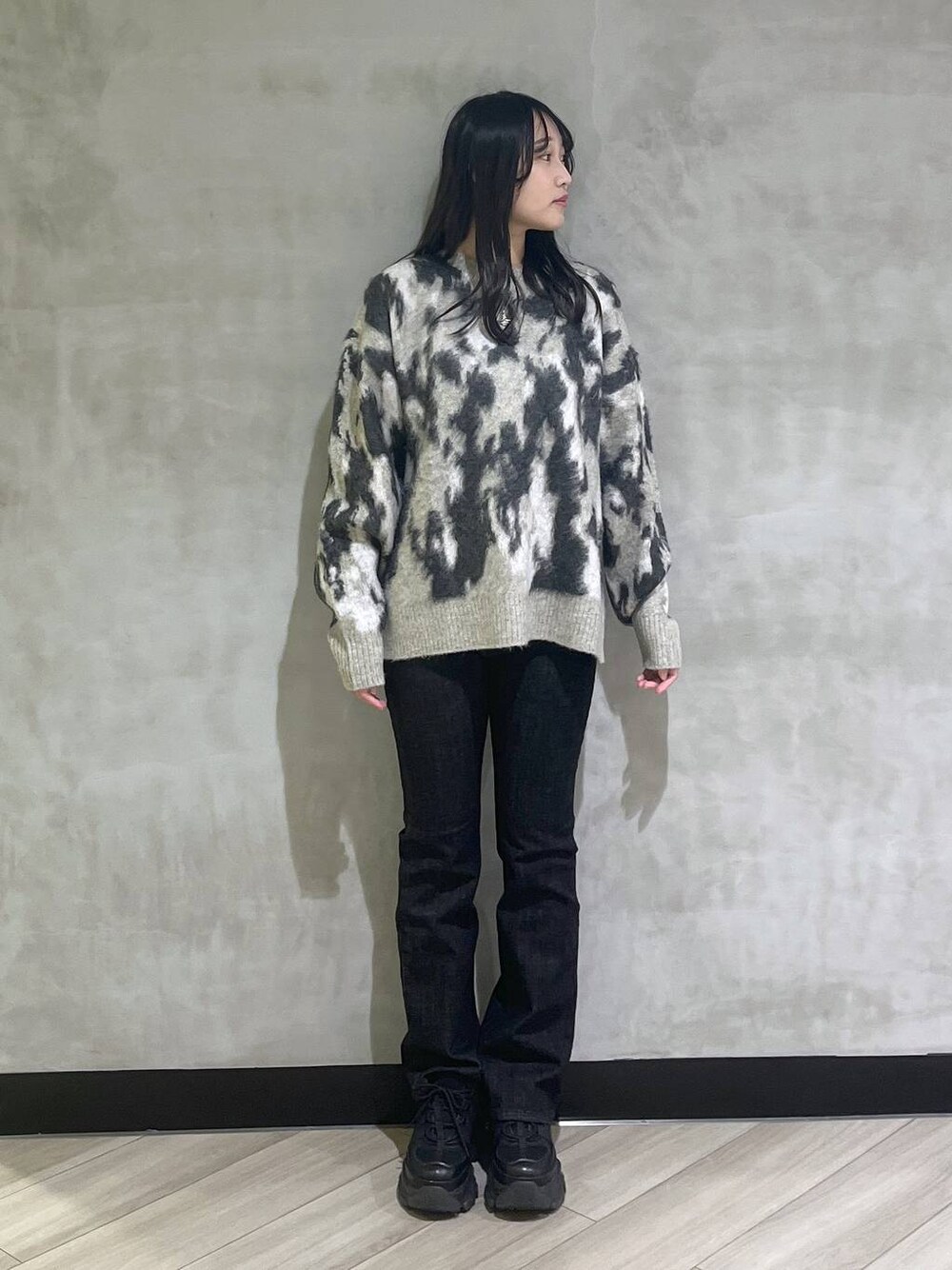 ブラック系のスニーカー、グレー系のニット/セーターを着用したレディースの秋コーディネートの1枚目の写真