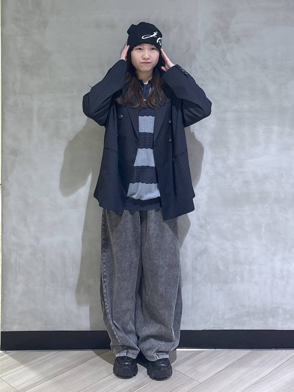 ブラック系のスニーカー、ブラック系のデニムパンツ、ブルー系のテーラードジャケットを着用したレディースの春コーディネートの1枚目の写真