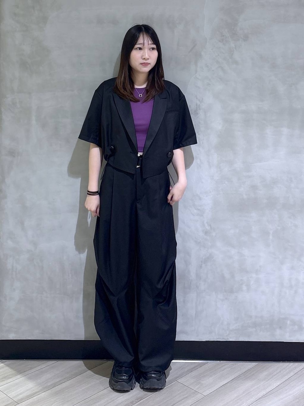 ブラック系のスニーカー、パープル系のTシャツ/カットソー、ブラック系のテーラードジャケットを着用したレディースの夏コーディネートの1枚目の写真