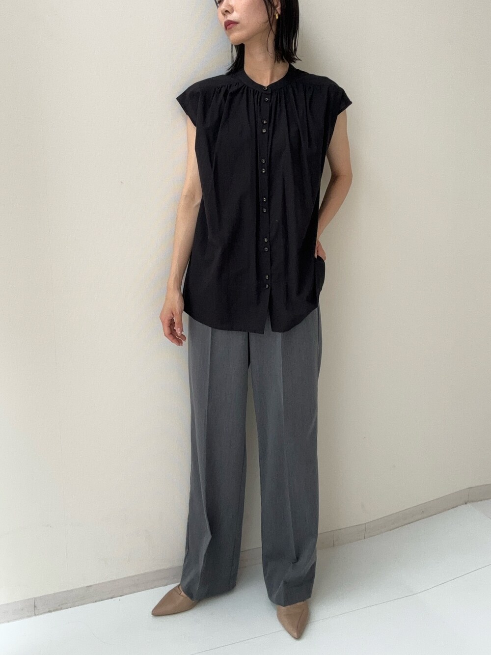 ブラック系のシャツ/ブラウス、グレー系のスラックスを着用したレディースの夏コーディネートの1枚目の写真