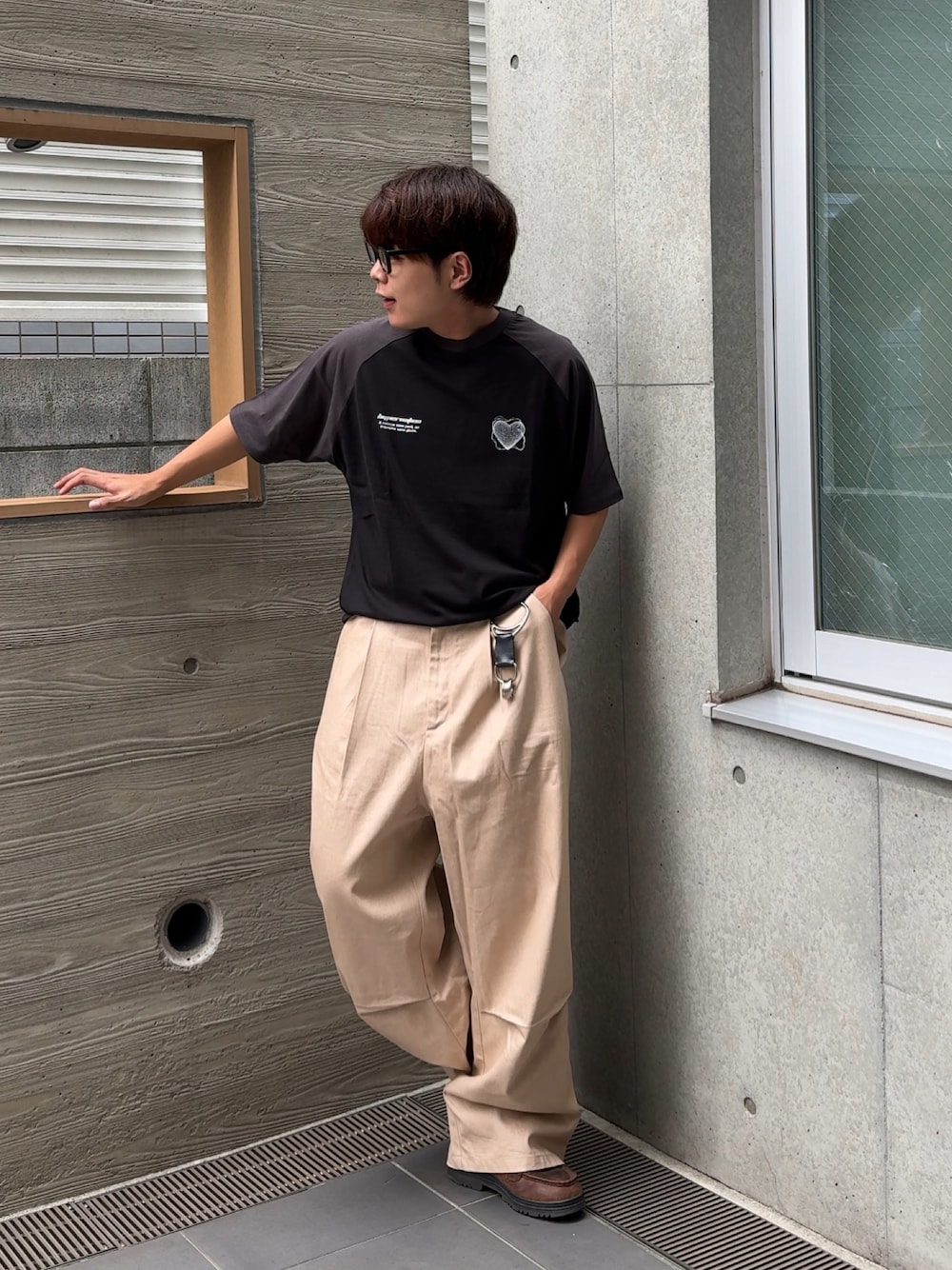 ブラック系のTシャツ/カットソー、ホワイト系のチノパンツ、ブラウン系のスニーカーを着用したメンズの夏コーディネートの1枚目の写真