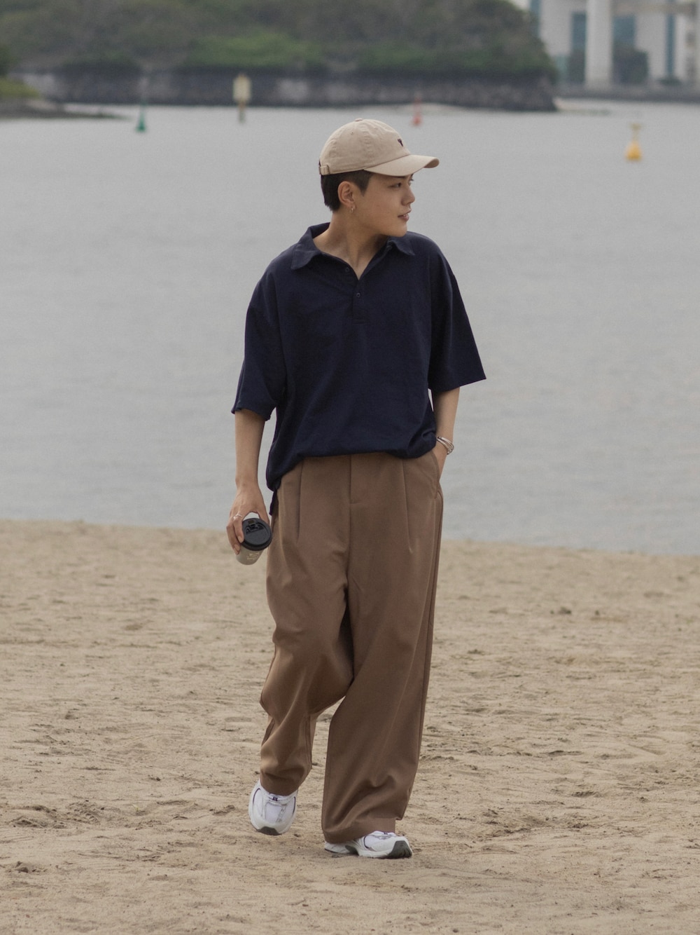 ブルー系のポロシャツ、ブラウン系のその他パンツ、ブラック系のスニーカーを着用したメンズの春コーディネートの1枚目の写真