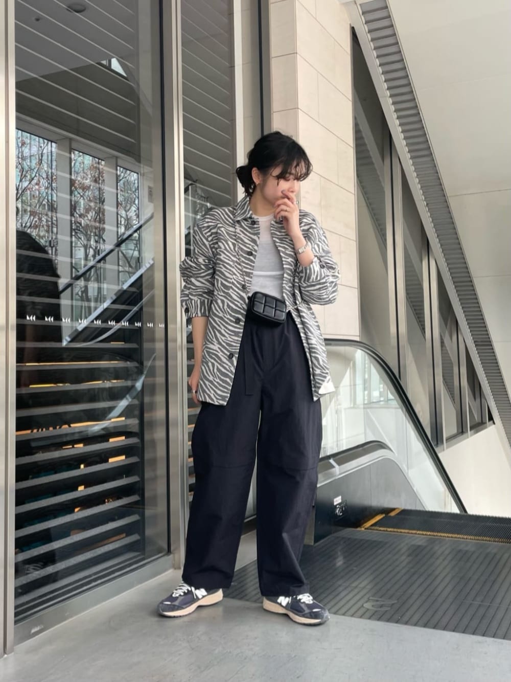 ブラック系のショルダーバッグ、ホワイト系のシャツ/ブラウス、ブラック系のその他パンツを着用したレディースの冬コーディネートの1枚目の写真