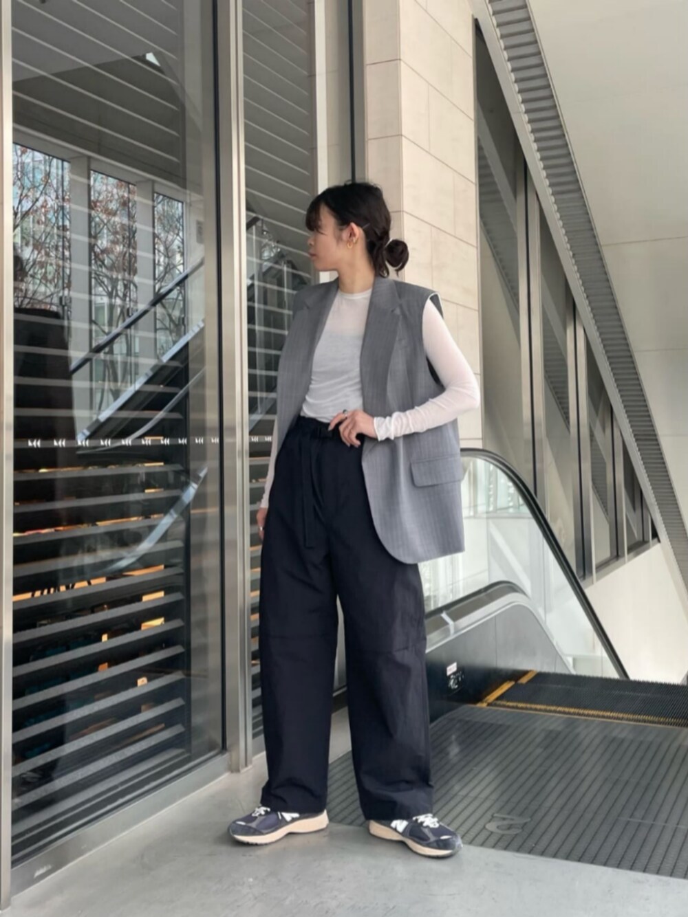 ブラック系のその他パンツ、ホワイト系のTシャツ/カットソー、グレー系のベストを着用したレディースの冬コーディネートの1枚目の写真