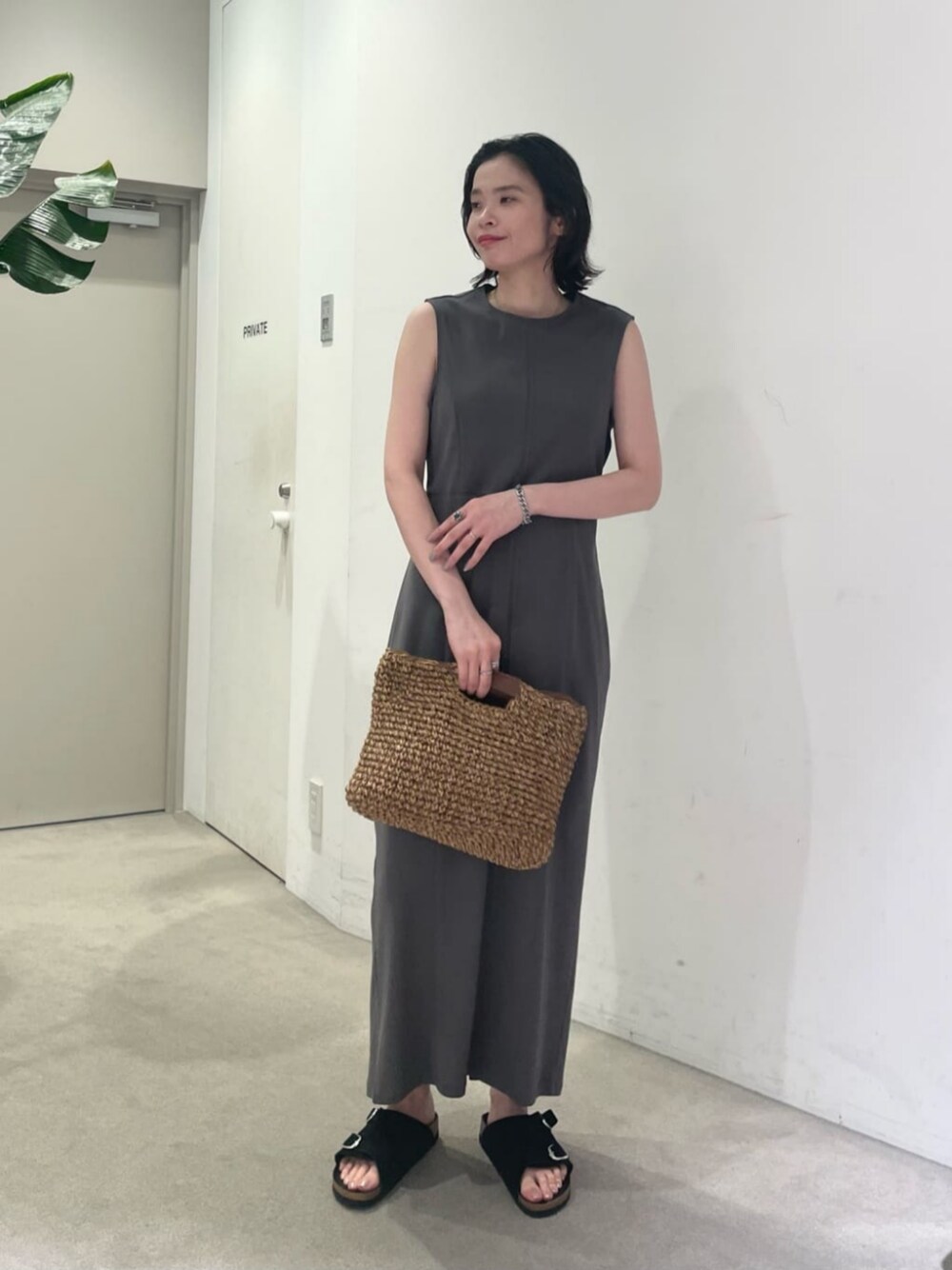 グレー系のワンピース、ブルー系のキャミソール、ブラウン系のかごバッグを着用したレディースの夏コーディネートの1枚目の写真