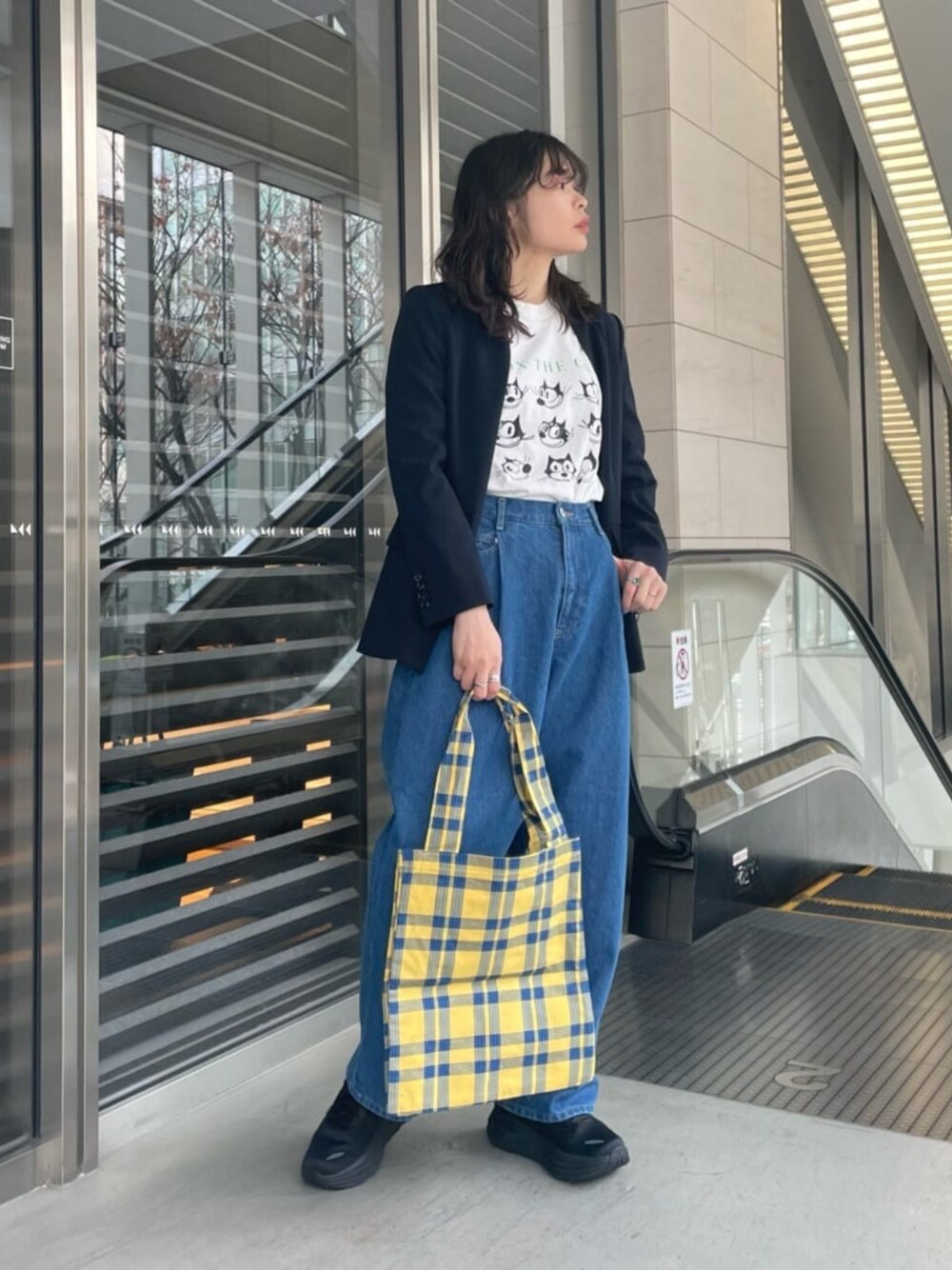 ブラック系のスニーカー、ブルー系のデニムパンツ、ブルー系のノーカラージャケットを着用したレディースの冬コーディネートの1枚目の写真