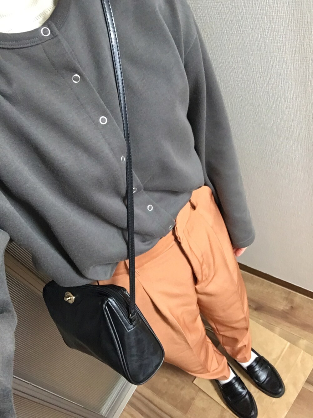 オレンジ系のその他パンツ、ブラック系のローファー、ブラック系のショルダーバッグを着用したレディースの冬コーディネートの1枚目の写真
