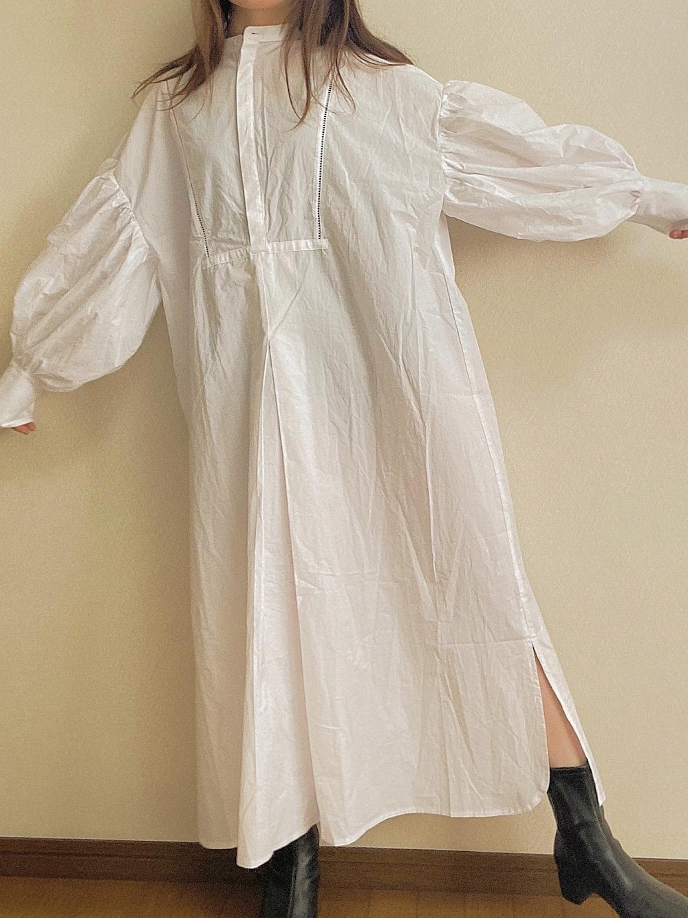 ホワイト系のシャツワンピース、ブラック系のブーツを着用したレディースの冬コーディネートの1枚目の写真