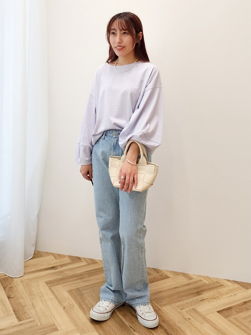 パープル系のTシャツ/カットソー、ホワイト系のショルダーバッグ、ブルー系のデニムパンツを着用したレディースの春コーディネートの1枚目の写真