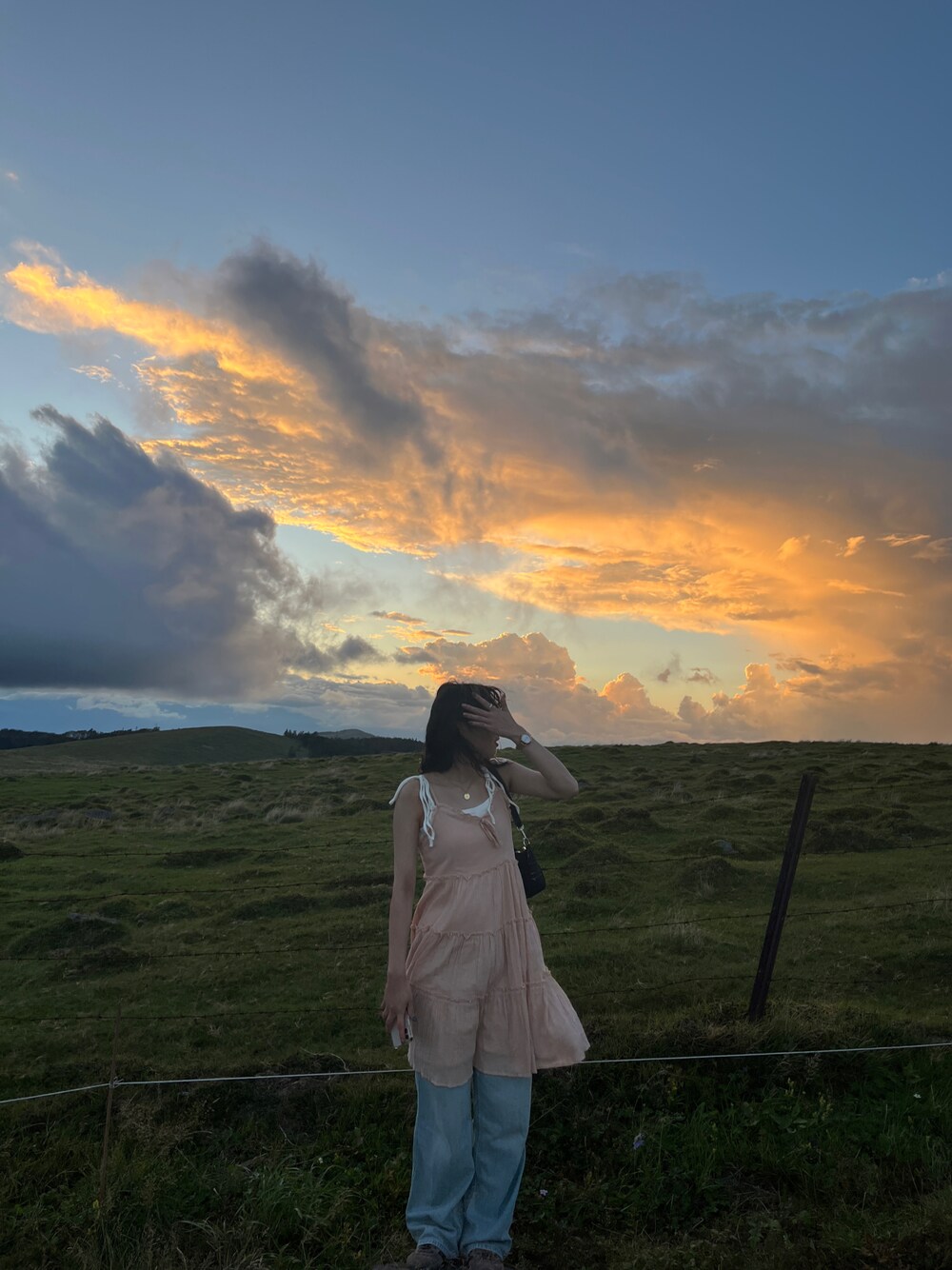 ピンク系のオールインワン・サロペット、ブルー系のデニムパンツを着用したレディースの秋コーディネートの1枚目の写真