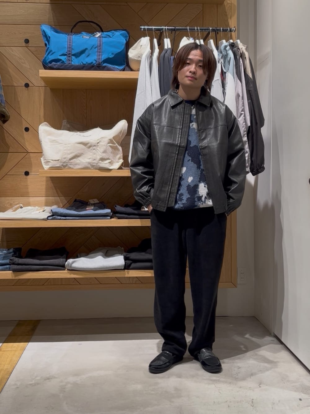 ブラック系のブルゾン、ブルー系のニット/セーター、ブラック系のその他パンツを着用したメンズの冬コーディネートの1枚目の写真