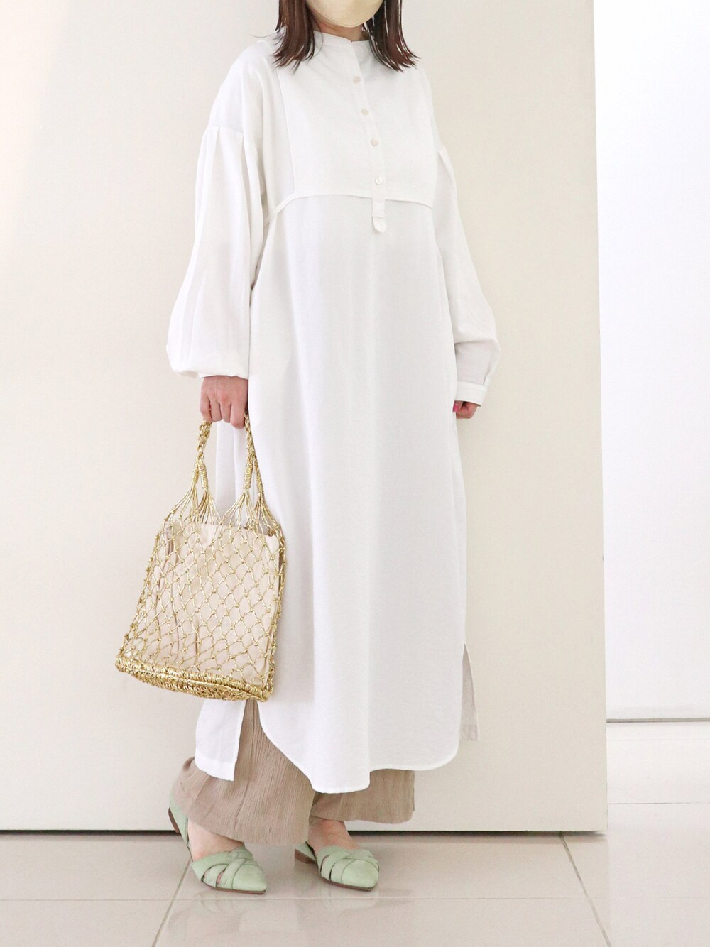 グリーン系のパンプスを着用したレディースの春コーディネートの1枚目の写真