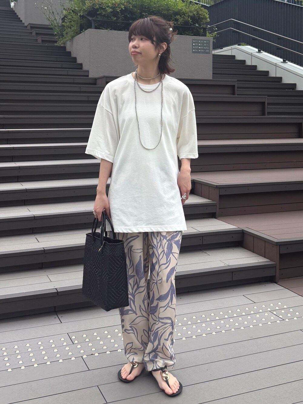 ベージュ系のその他パンツ、ホワイト系のTシャツ/カットソー、シルバー系のネックレスを着用したレディースの春コーディネートの1枚目の写真