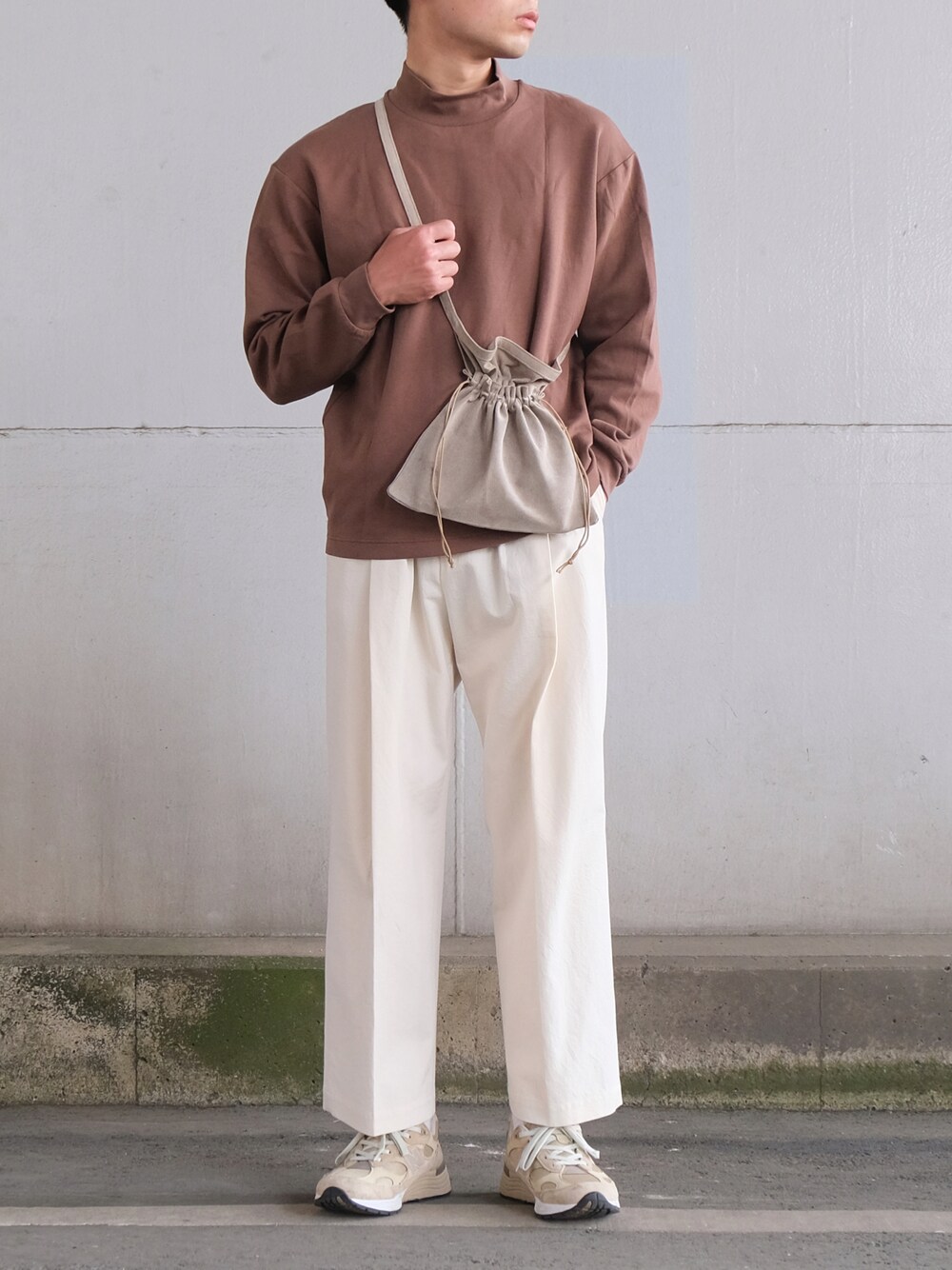 ブラウン系のTシャツ/カットソー、ベージュ系のショルダーバッグ、ホワイト系のパンツを着用したメンズの春コーディネートの1枚目の写真