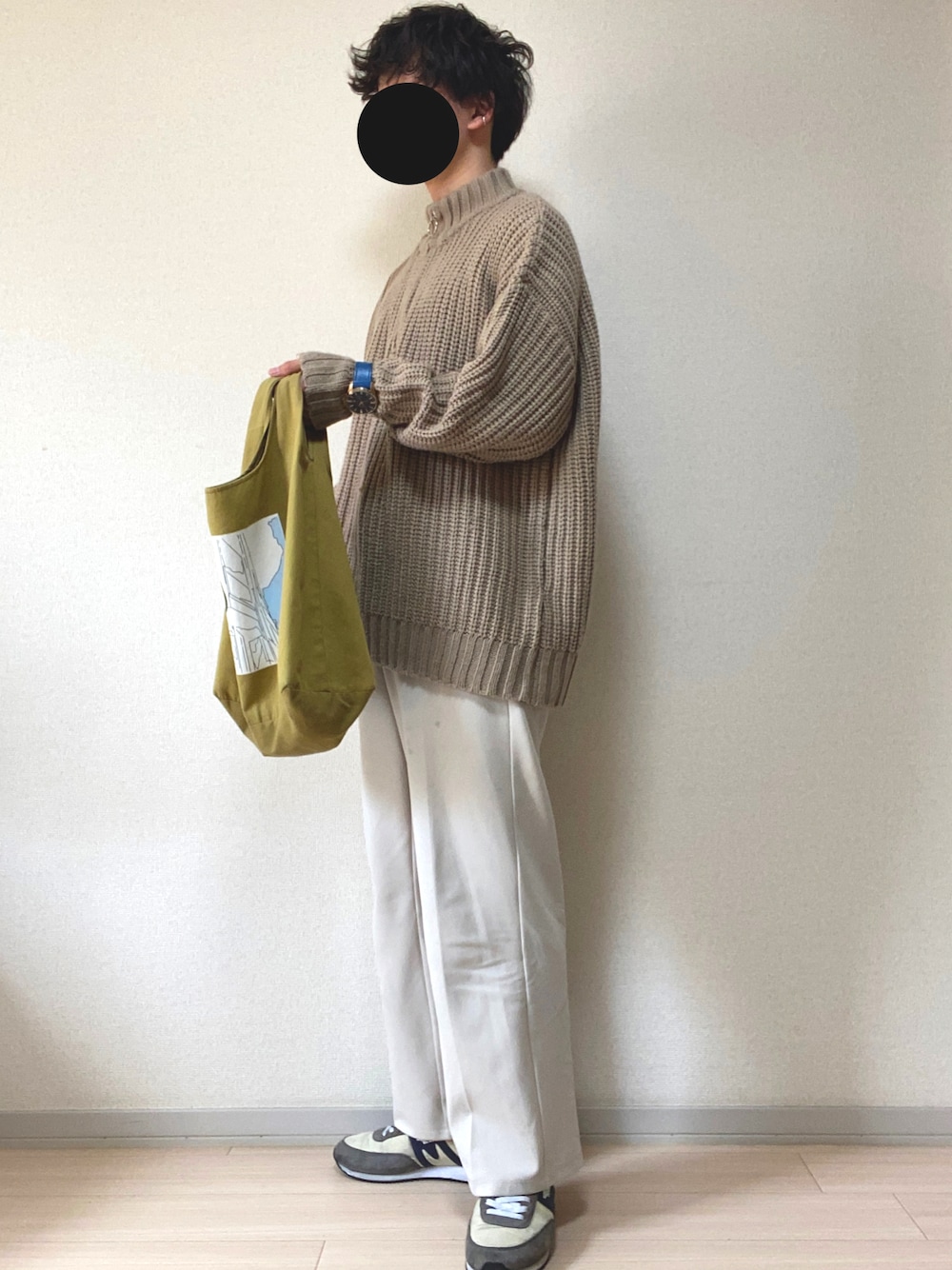 ベージュ系のニット/セーター、ホワイト系のスラックス、グレー系のスニーカーを着用したメンズの春コーディネートの1枚目の写真