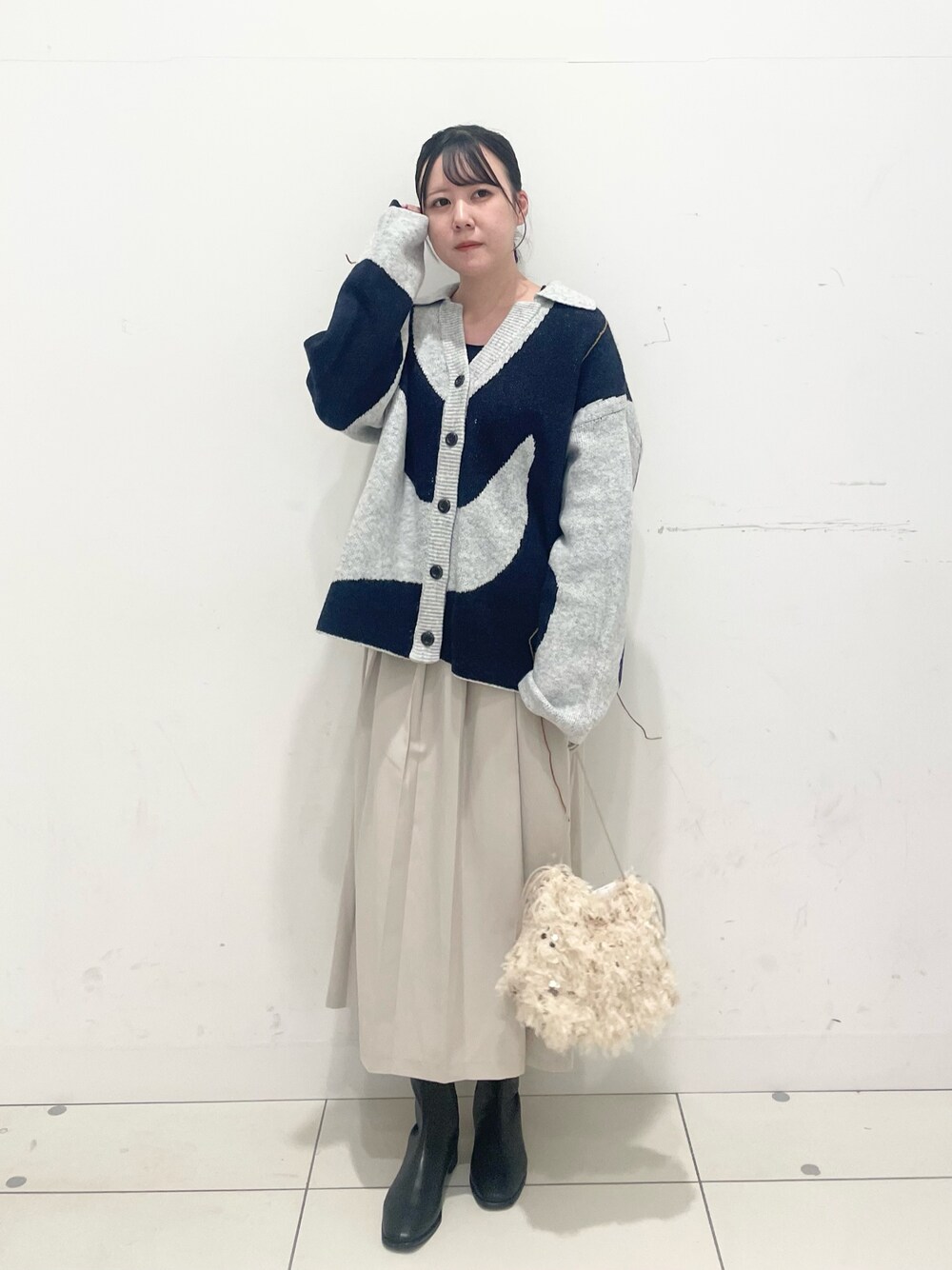 ブルー系のTシャツ/カットソー、ホワイト系のカーディガン/ボレロ、ベージュ系のスカートを着用したレディースの秋コーディネートの1枚目の写真