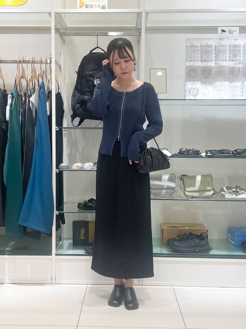 ブラック系のショルダーバッグ、ブラック系のサンダル、ブラック系のスカートを着用したレディースの夏コーディネートの1枚目の写真