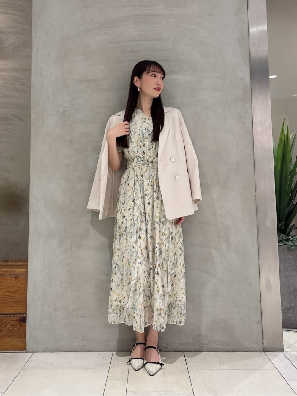 イエロー系のワンピース、ホワイト系のテーラードジャケットを着用したレディースの春コーディネートの1枚目の写真