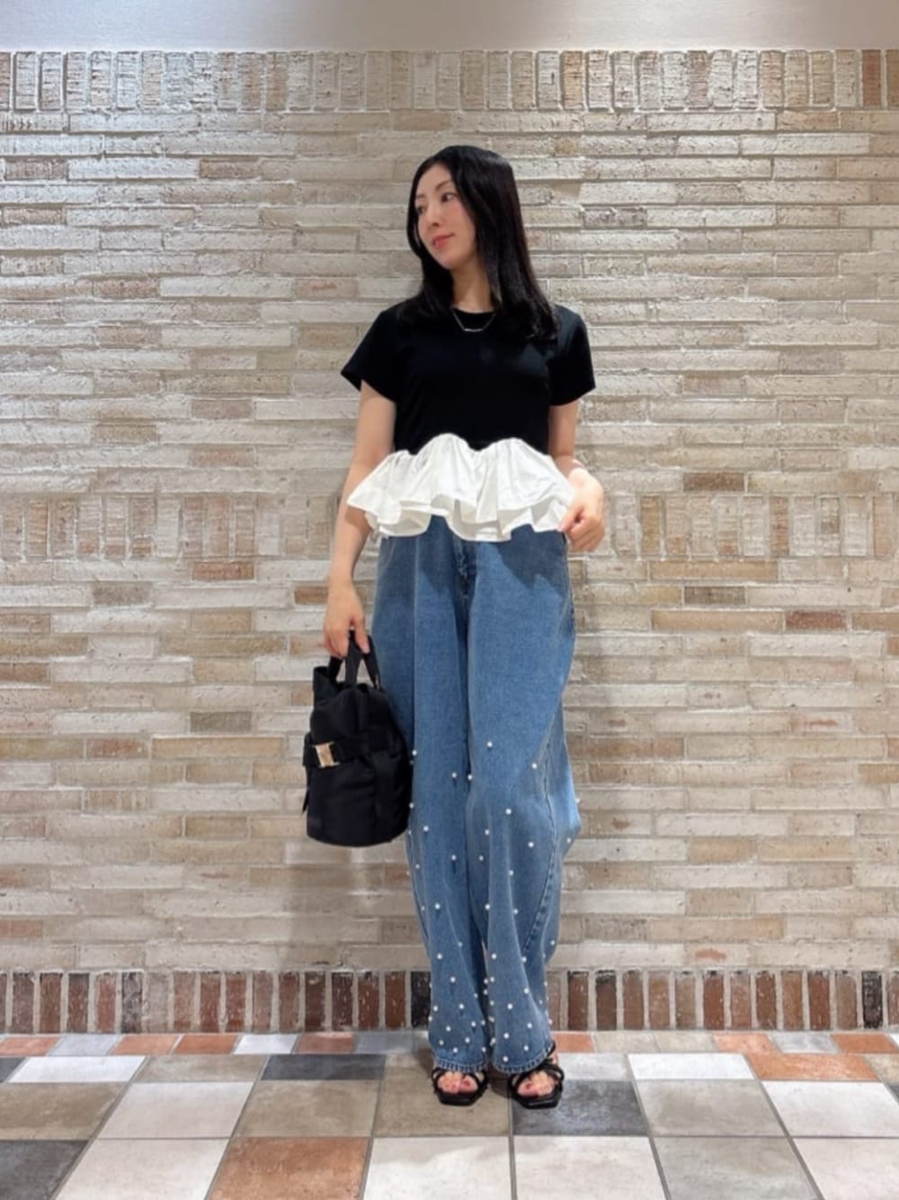 ブラック系のパンプス、ブラック系のTシャツ/カットソー、ブルー系のデニムパンツを着用したレディースの夏コーディネートの1枚目の写真