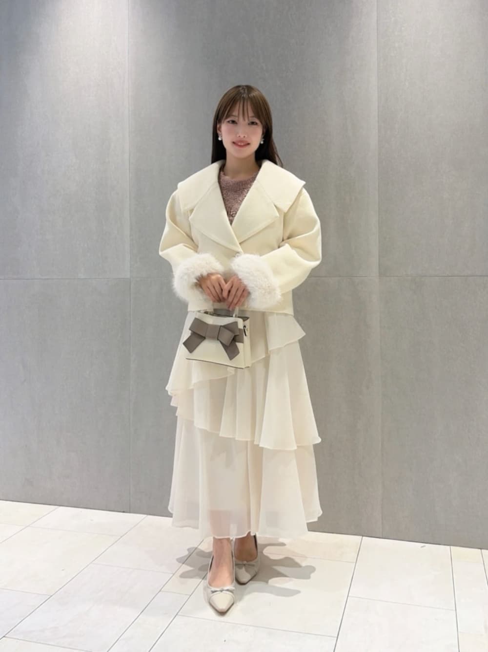 ベージュ系のパンプス、ホワイト系のショルダーバッグ、ピンク系のニット/セーターを着用したレディースの秋コーディネートの1枚目の写真