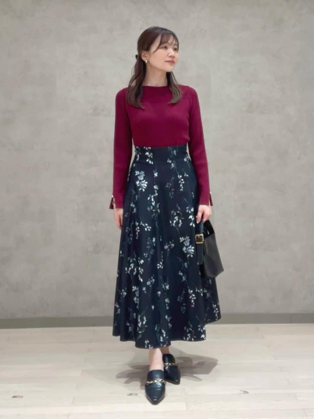 ブラック系のスカート、レッド系のニット/セーターを着用したレディースの秋コーディネートの1枚目の写真