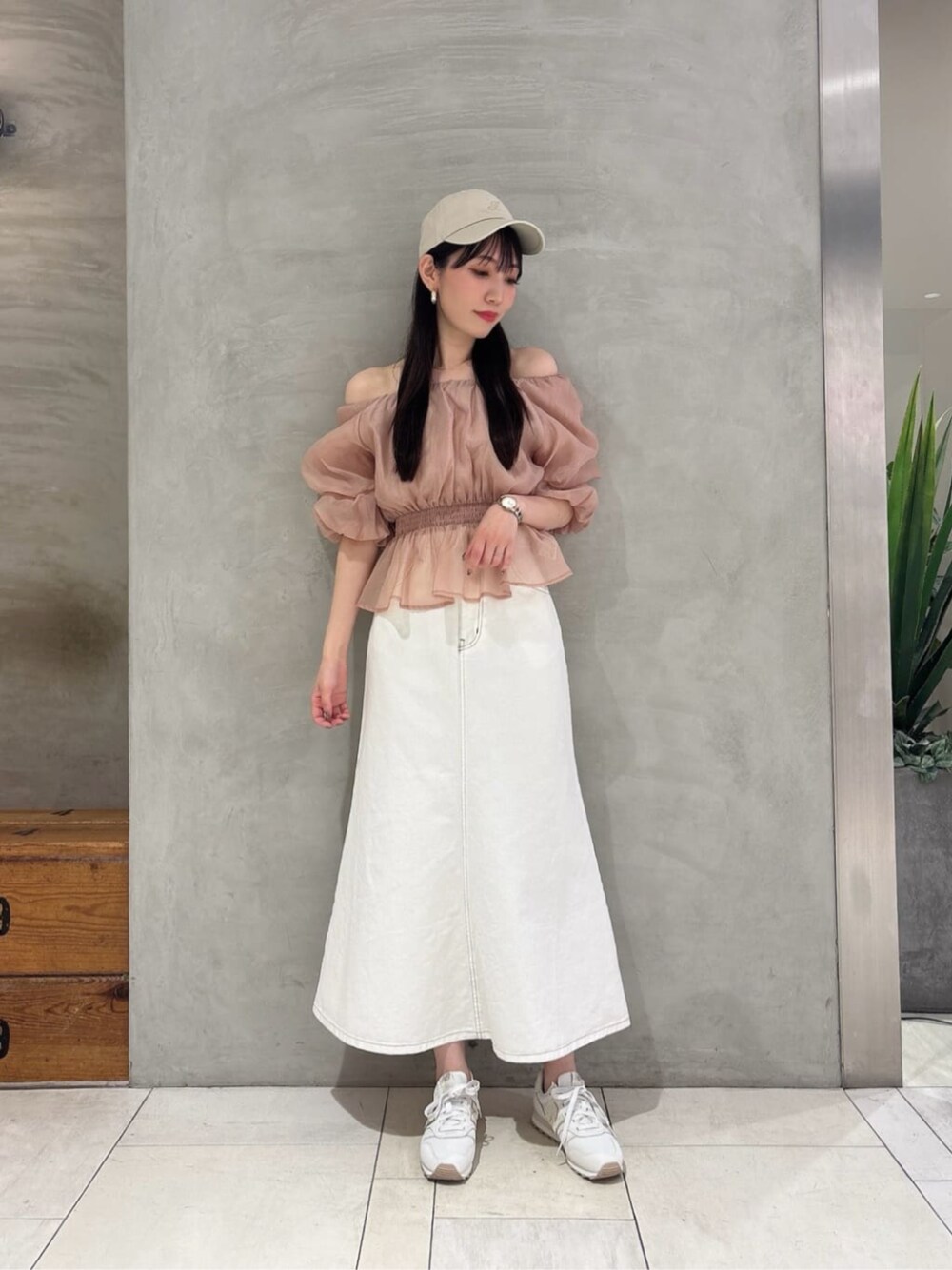 ベージュ系のシャツ/ブラウス、ホワイト系のスカート、ベージュ系のキャップを着用したレディースの春コーディネートの1枚目の写真