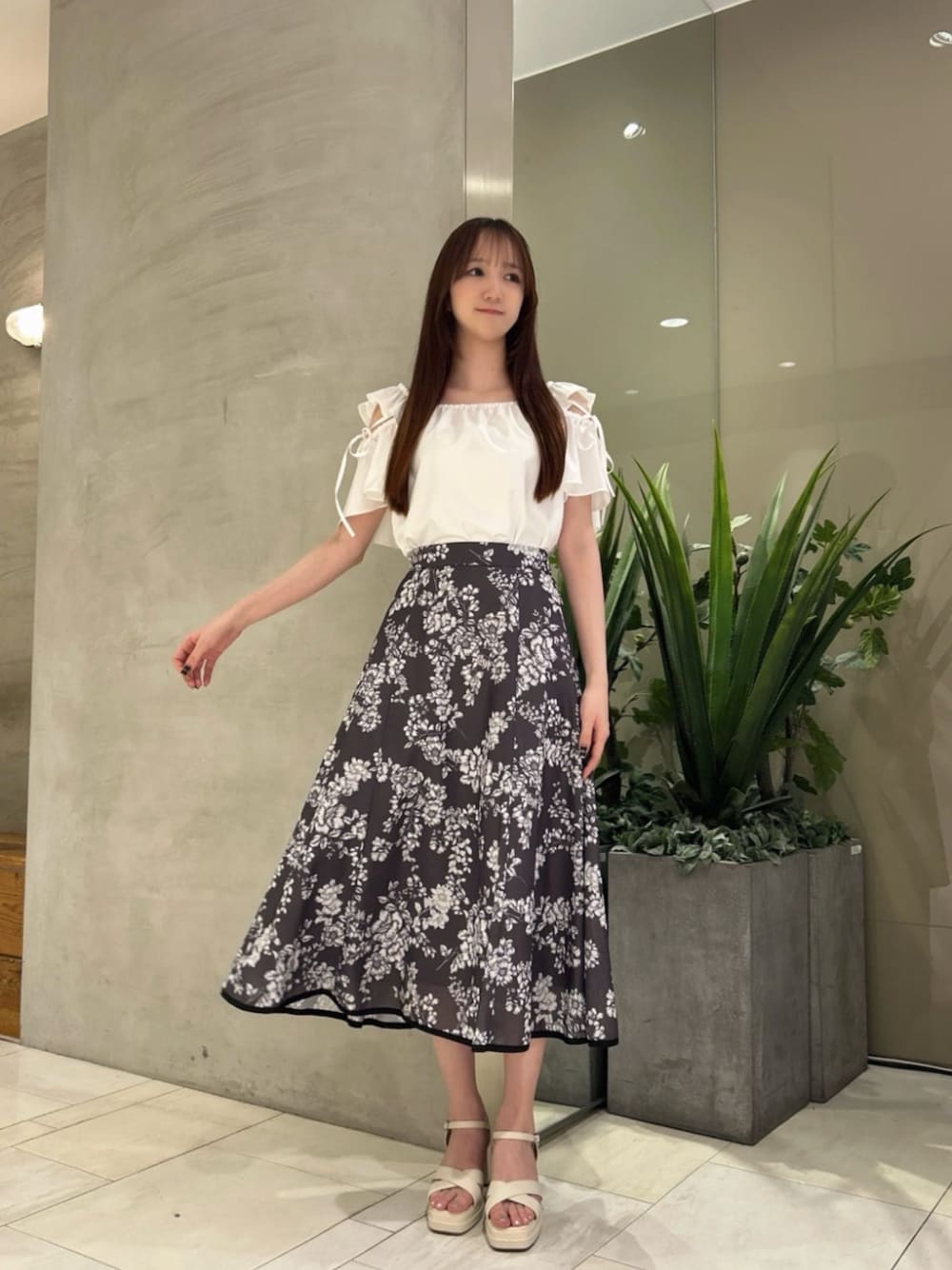 ホワイト系のシャツ/ブラウス、グレー系のスカートを着用したレディースの夏コーディネートの1枚目の写真